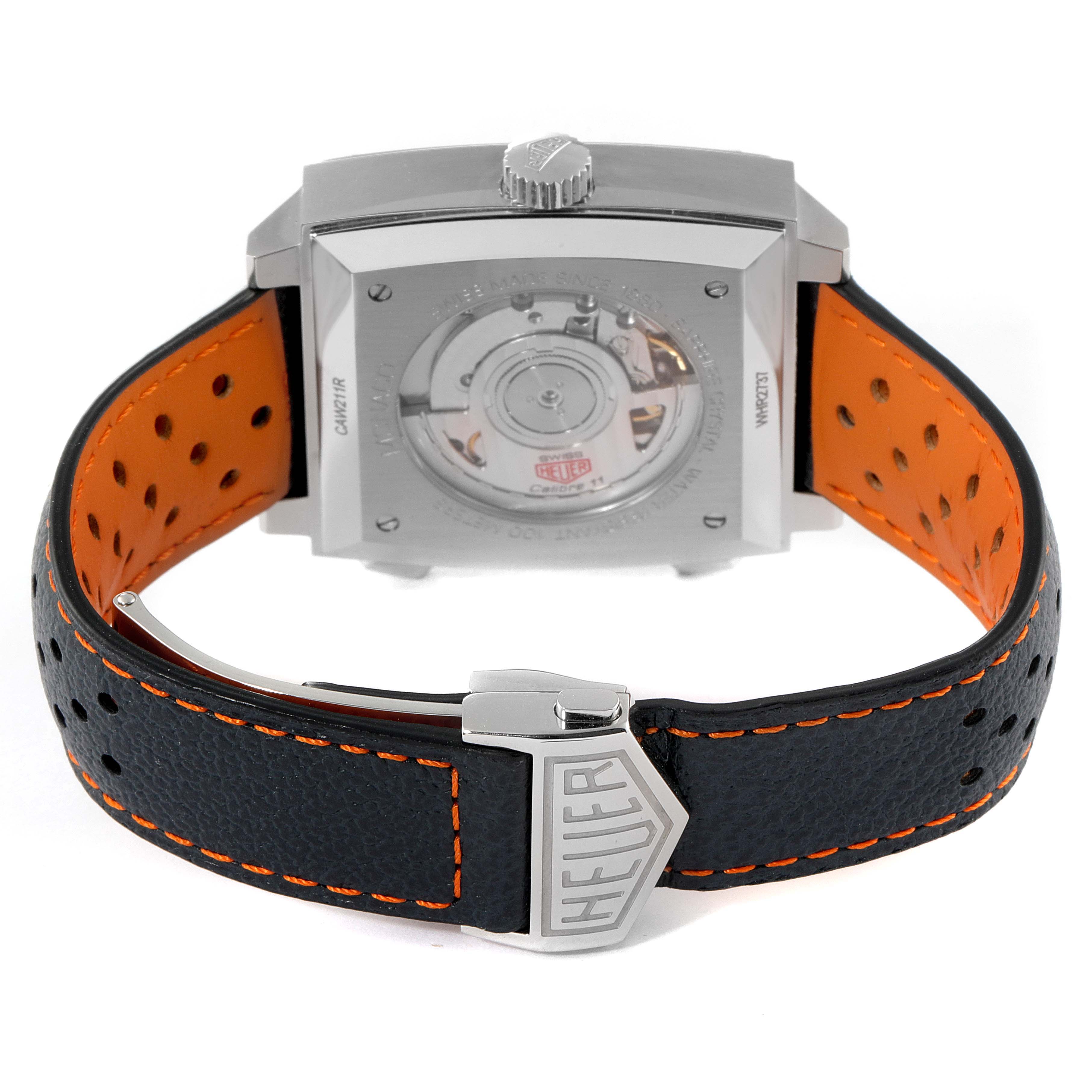 The image shows the back view of the Tag Heuer Monaco CAW211R.FC6401 Men's Stainless Steel Blue Dial CAW211R.FC6401 Men's Stainless Steel Blue Dial watch, highlighting its movement and leather strap with a Heuer buckle.