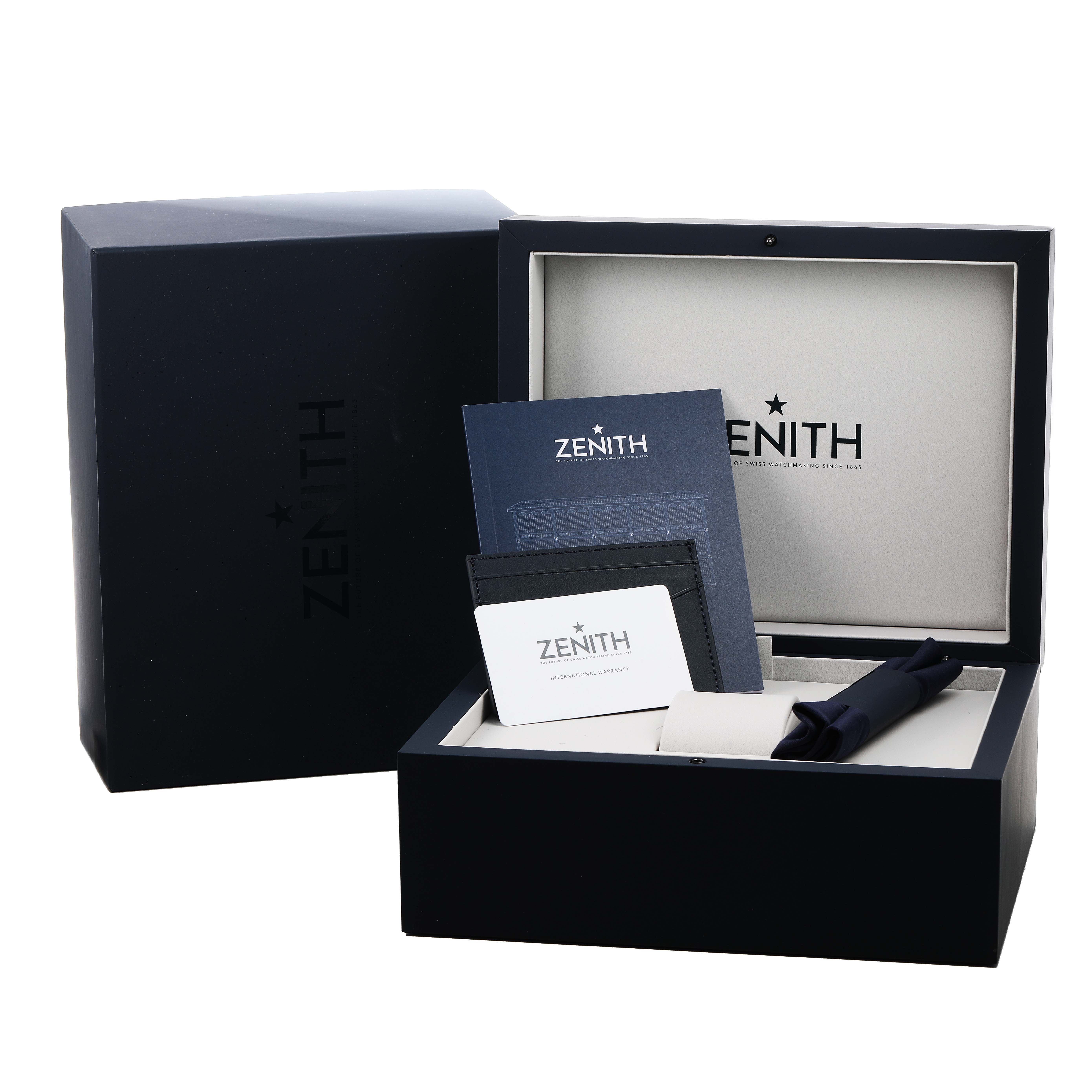 The image shows the packaging for the Zenith Chronomaster 03.3107.3600 Men's Stainless Steel Green Dial, including the box, manual, wallet, and cloth.