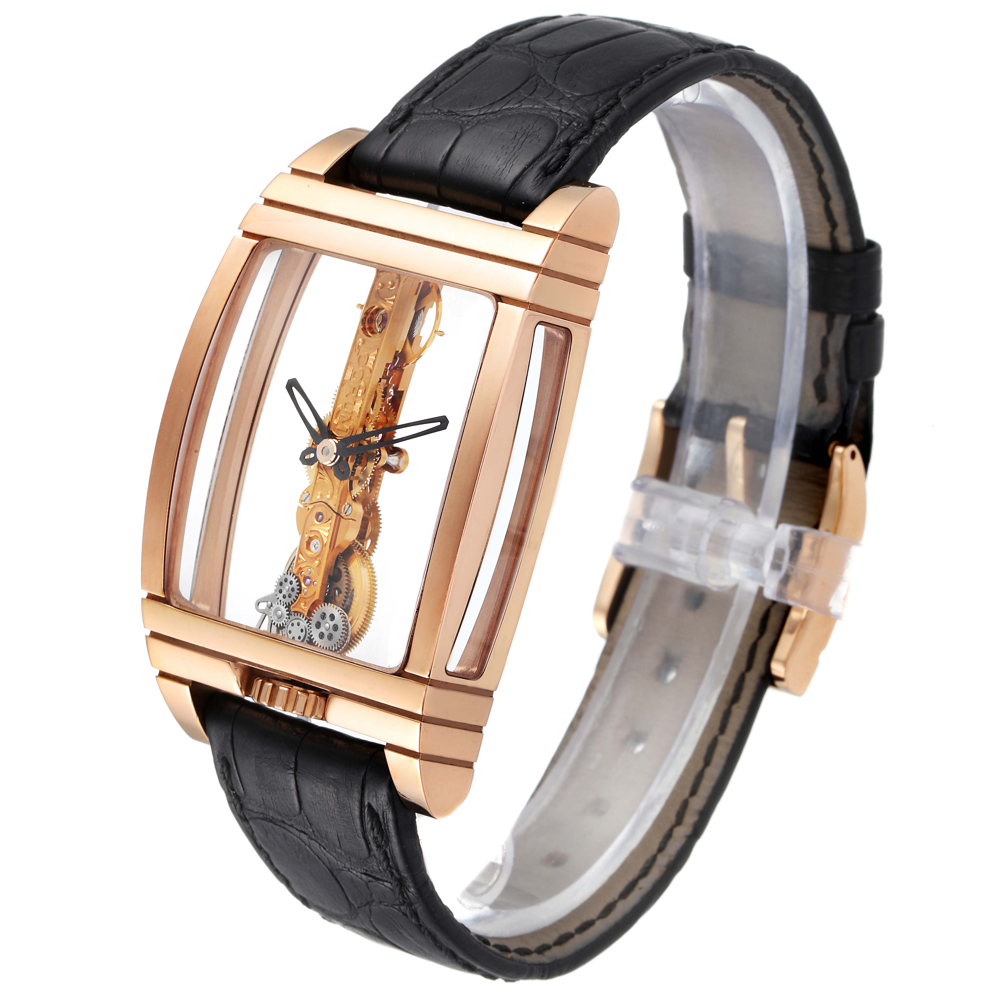 This is a Corum Golden Bridge B113/01043 - 113.160.55/0002 0000 Men's Rose Gold Transparent Dial B113/01043 - 113.160.55/0002 0000 Men's Rose Gold Transparent Dial watch, shown at an oblique angle showcasing its rectangular case, intricate mechanism, and black leather strap.