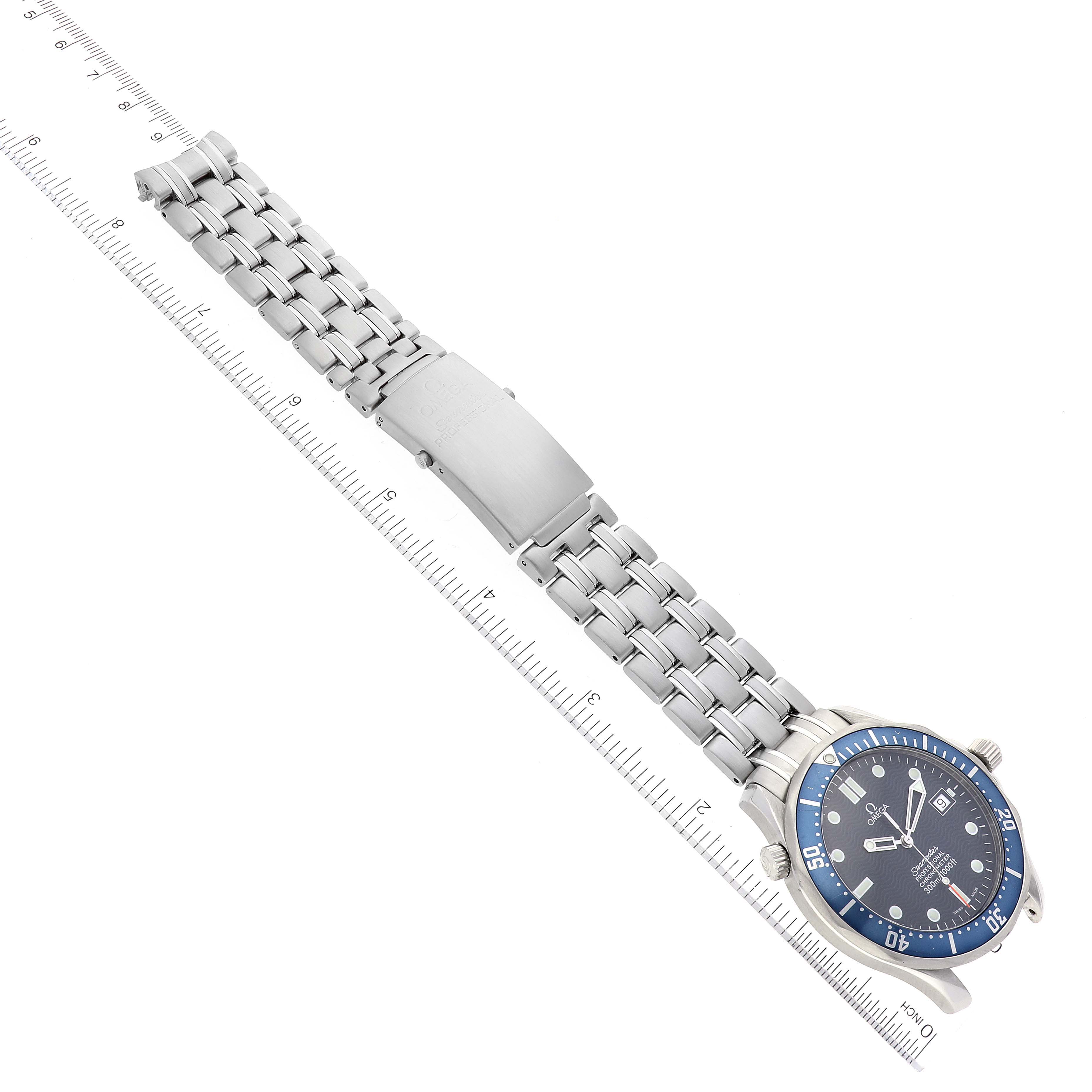 The image shows an Omega Seamaster 2531.80.00 Men's Stainless Steel Blue Dial 2531.80.00 Men's Stainless Steel Blue Dial watch from an overhead angle, with visible blue dial, bezel, and silver metal bracelet against a ruler backdrop.