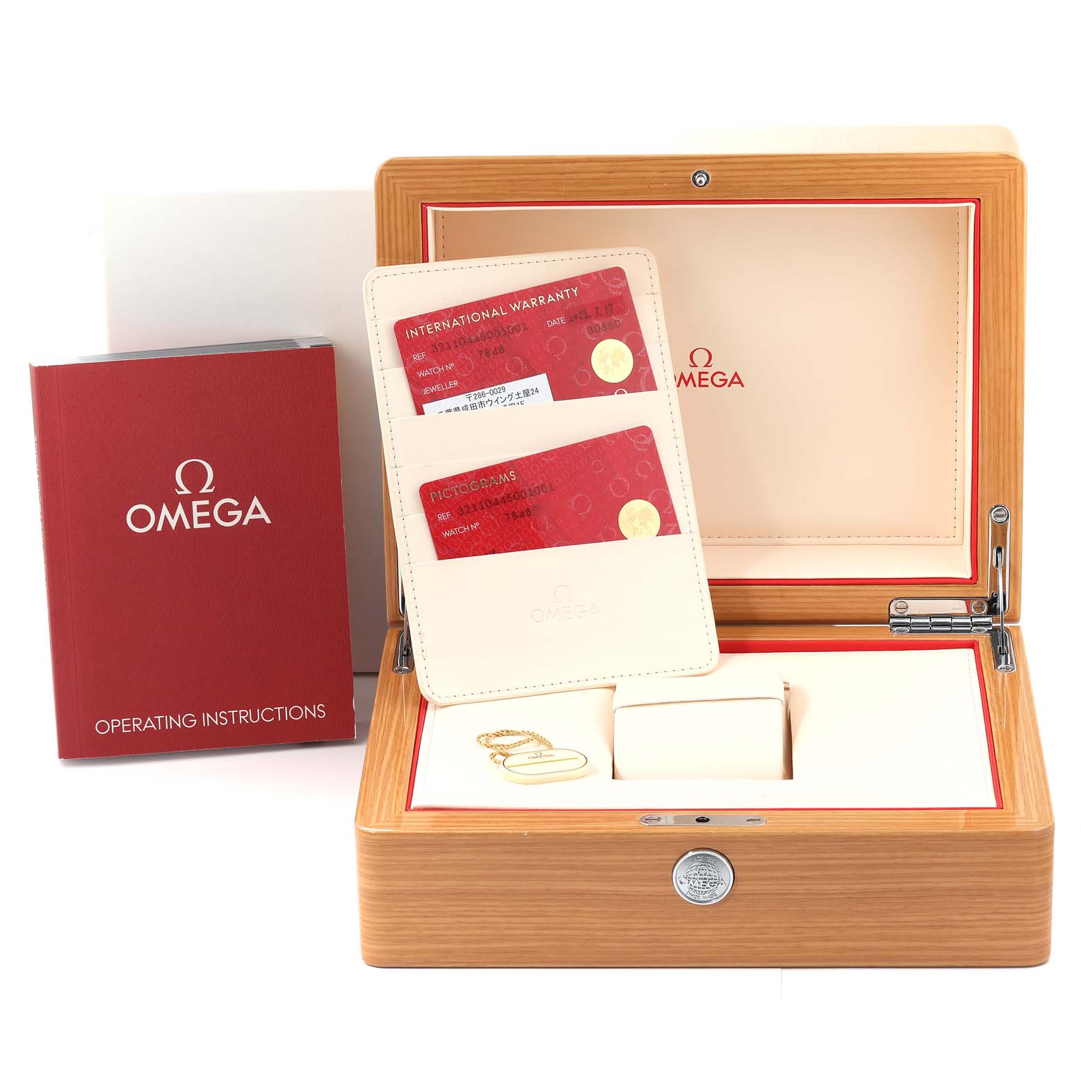 The image shows an Omega Speedmaster 321.10.44.50.01.001 Men
s Stainless Steel Black Dial 321.10.44.50.01.001 Men
s Stainless Steel Black Dial watch
s box, operating instructions booklet, warranty cards, and a cardholder from a front angle.