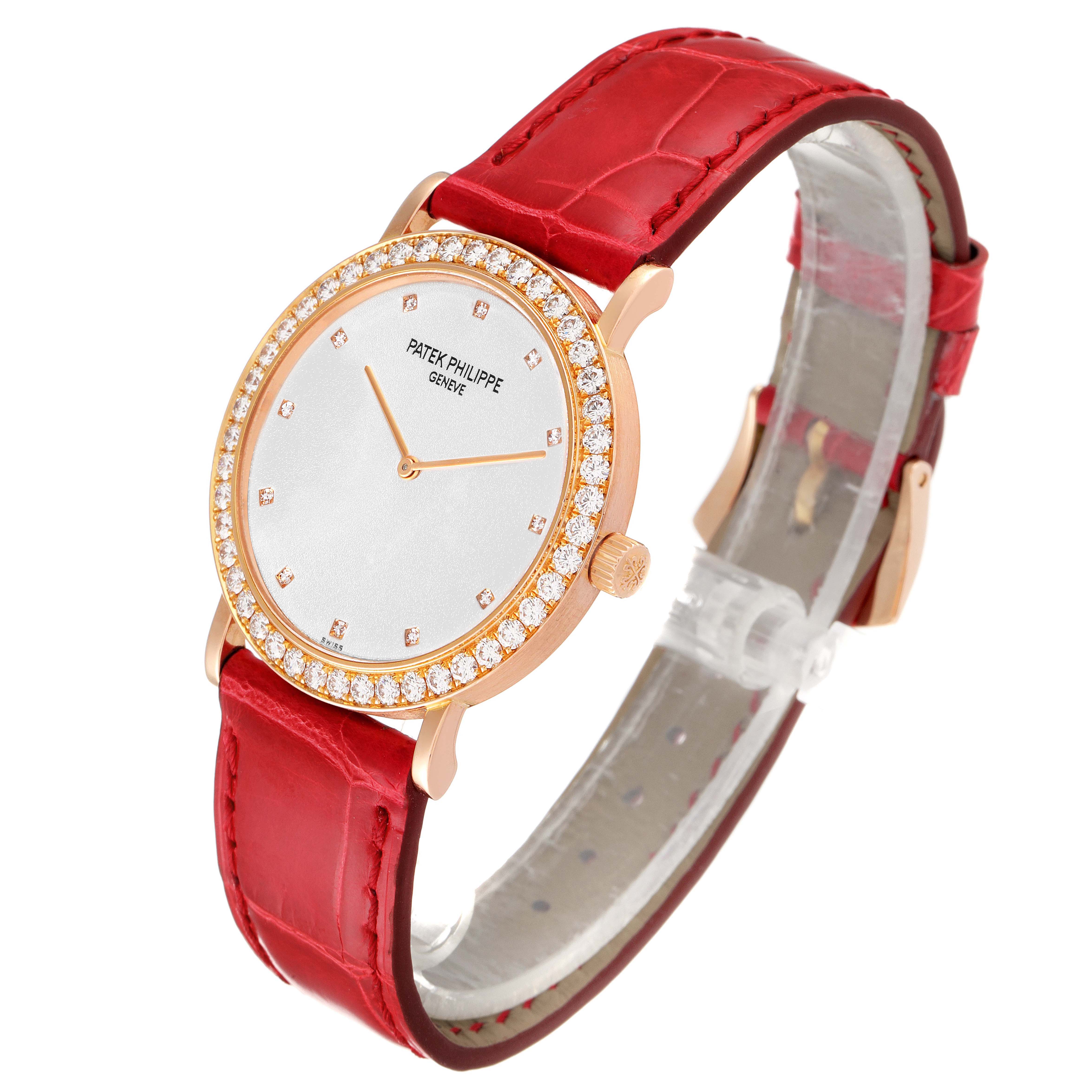 The Patek Philippe Calatrava 5006R Men's Rose Gold Silver Dial 5006R Men's Rose Gold Silver Dial watch is shown at a front three-quarter angle, highlighting its red strap, diamond bezel, and gold case.