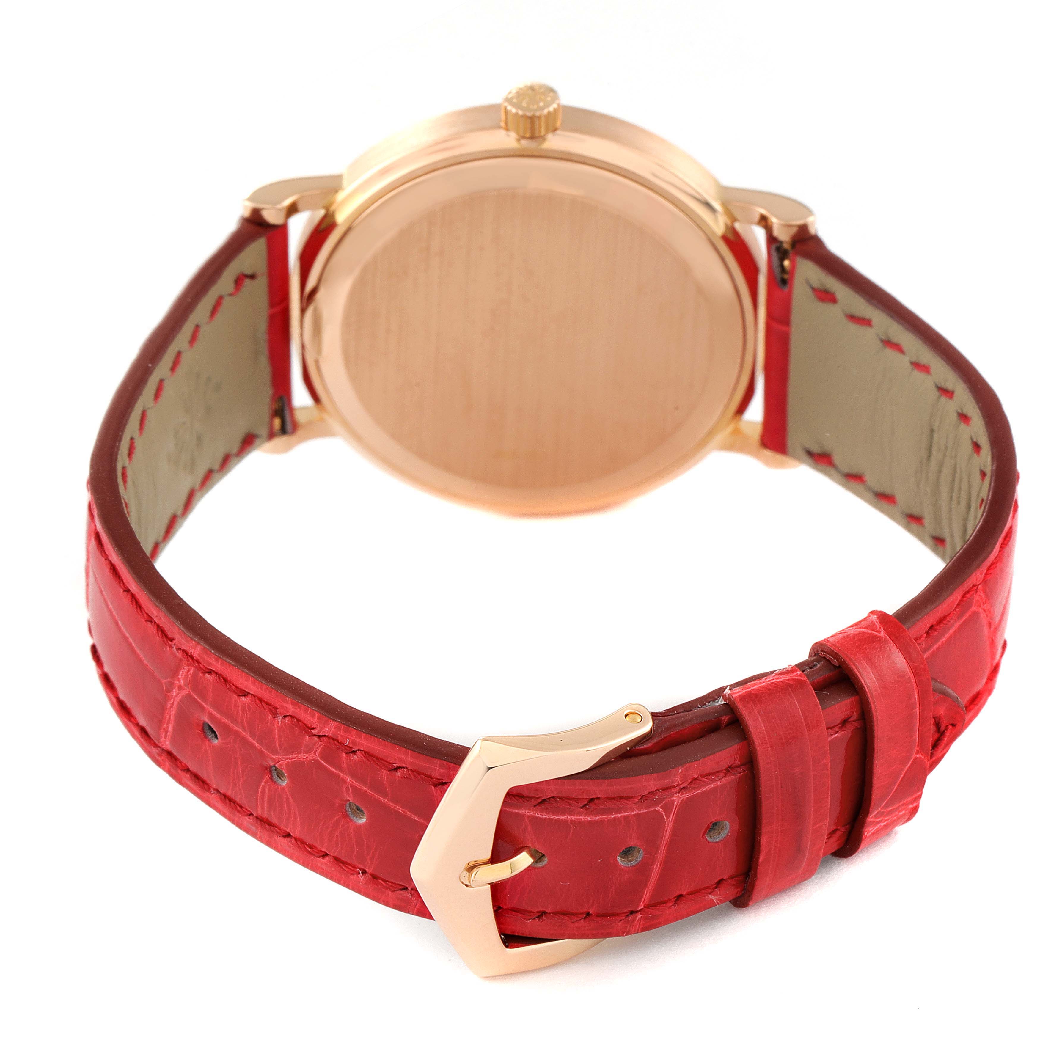 This image shows the back of a Patek Philippe Calatrava 5006R Men's Rose Gold Silver Dial 5006R Men's Rose Gold Silver Dial watch with a red leather strap and gold buckle.