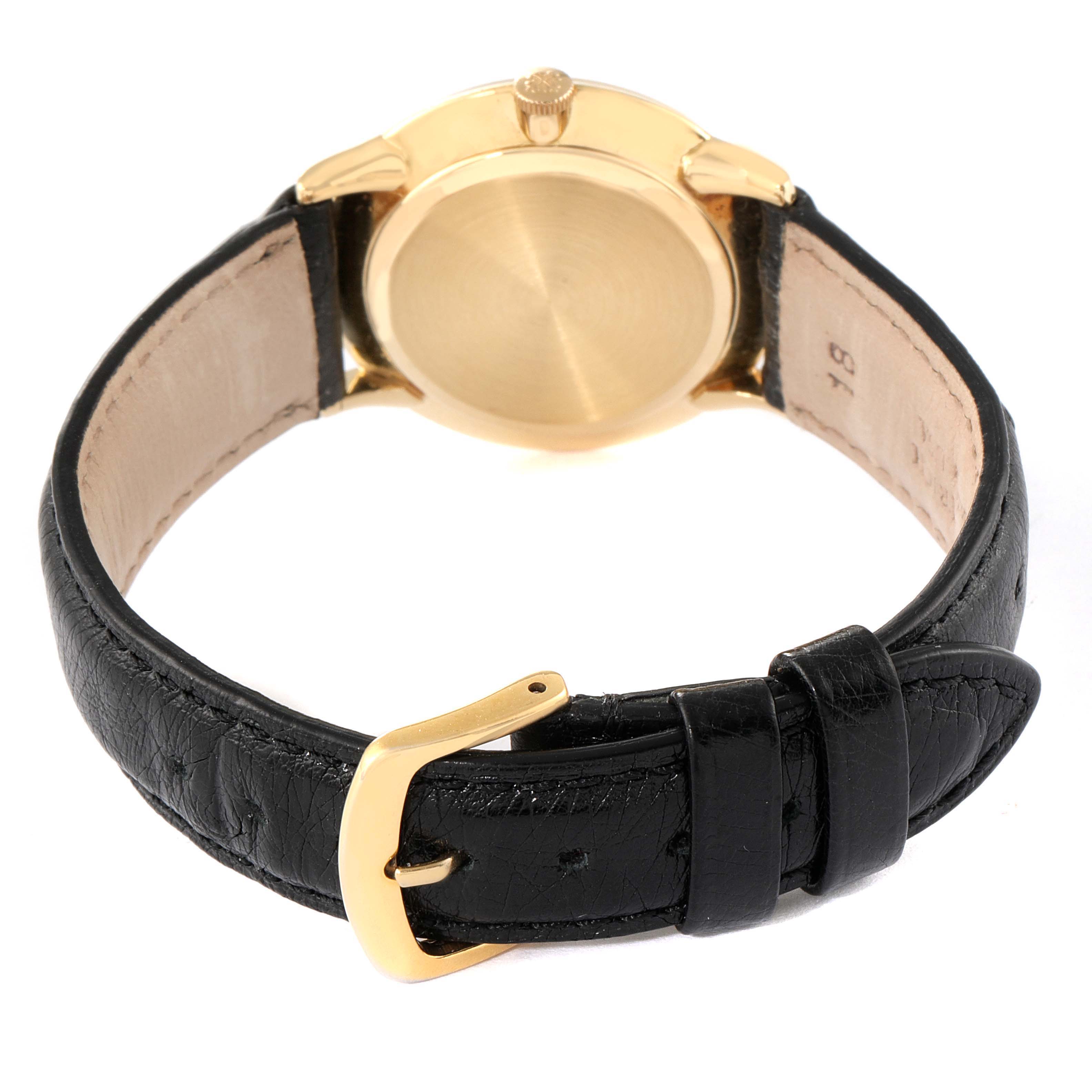 The image shows the back of a Vintage Patek Philippe watch with a black leather strap and gold buckle.