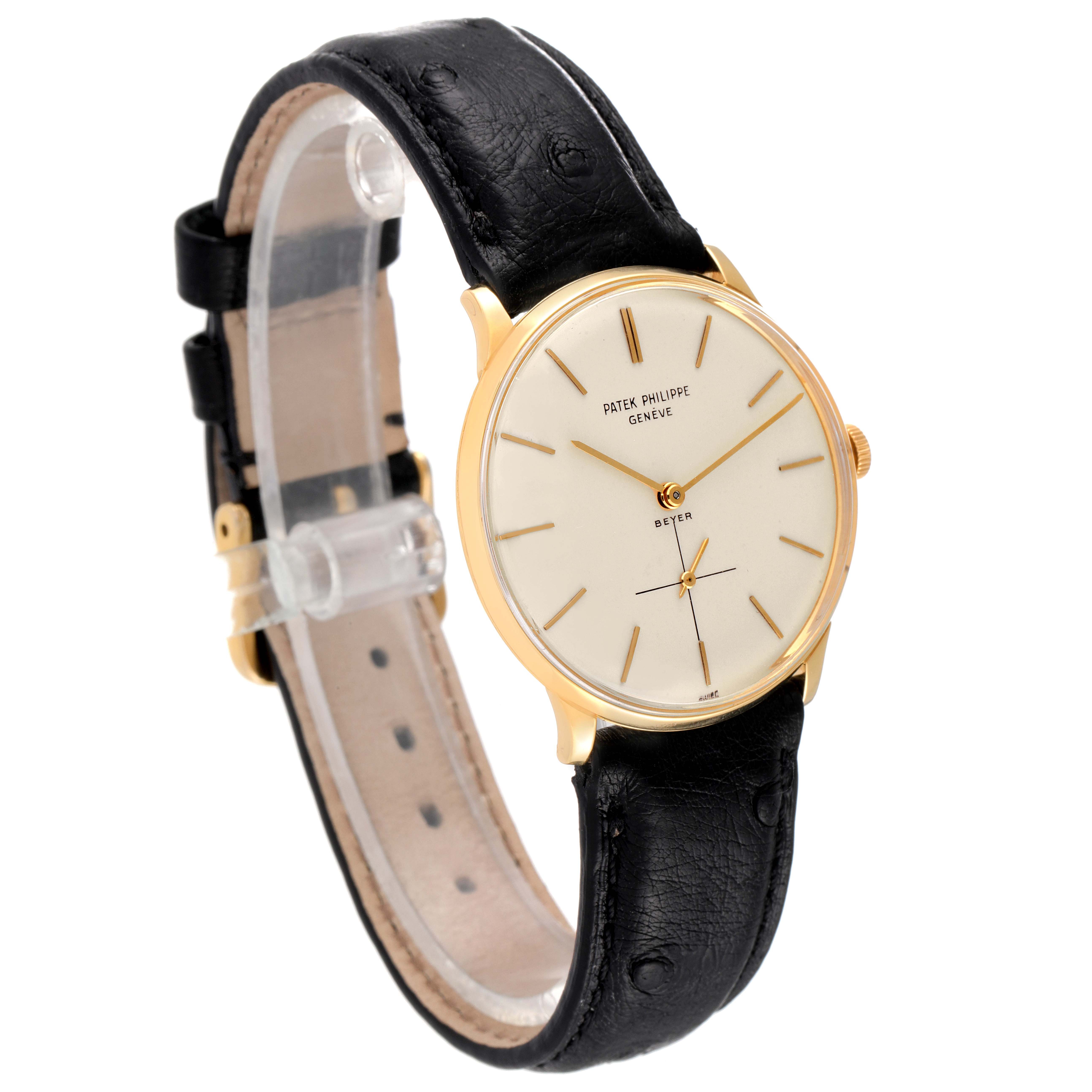 This image shows a side-angle view of a Vintage Patek Philippe watch featuring a gold case, white dial, and black leather strap.