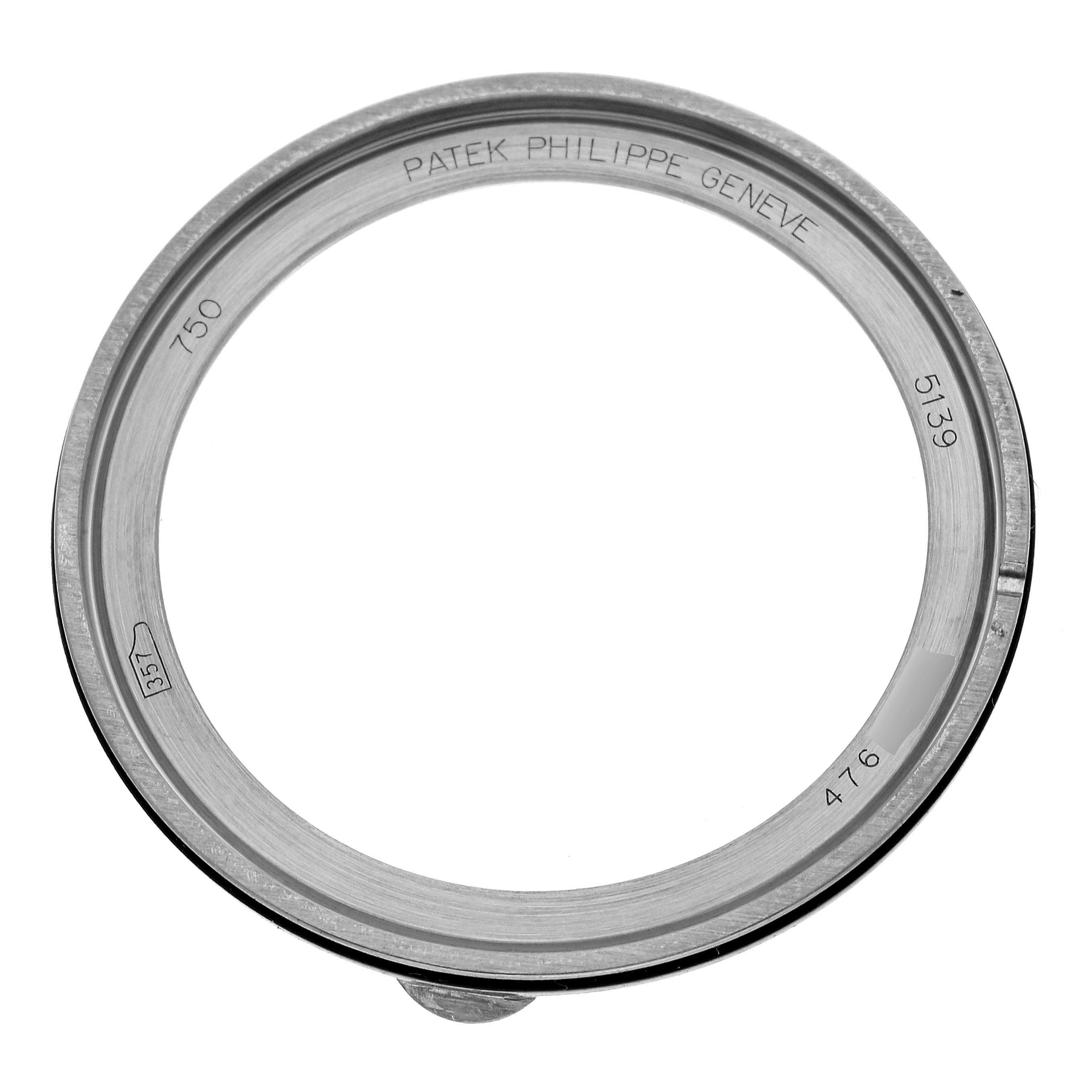 This is a circular bezel from a Patek Philippe Complications 5139G Men's White Gold Black Dial 5139G Men's White Gold Black Dial watch, seen from a top angle, showing the inscribed text.