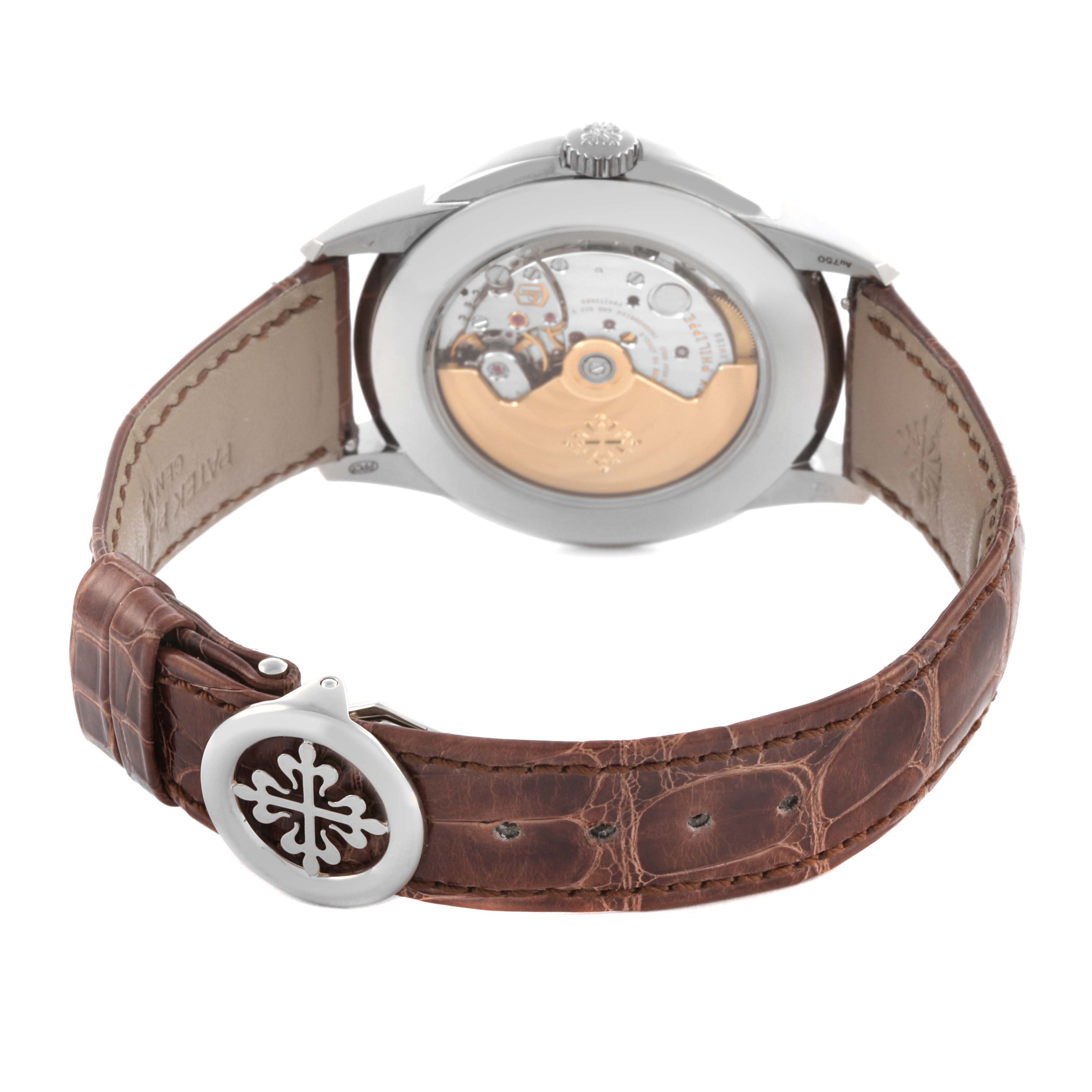 The Patek Philippe Complications 5320G-001 Men's White Gold White Dial 5320G-001 Men's White Gold White Dial watch is shown from the back, highlighting the movement and leather strap with a decorative clasp.