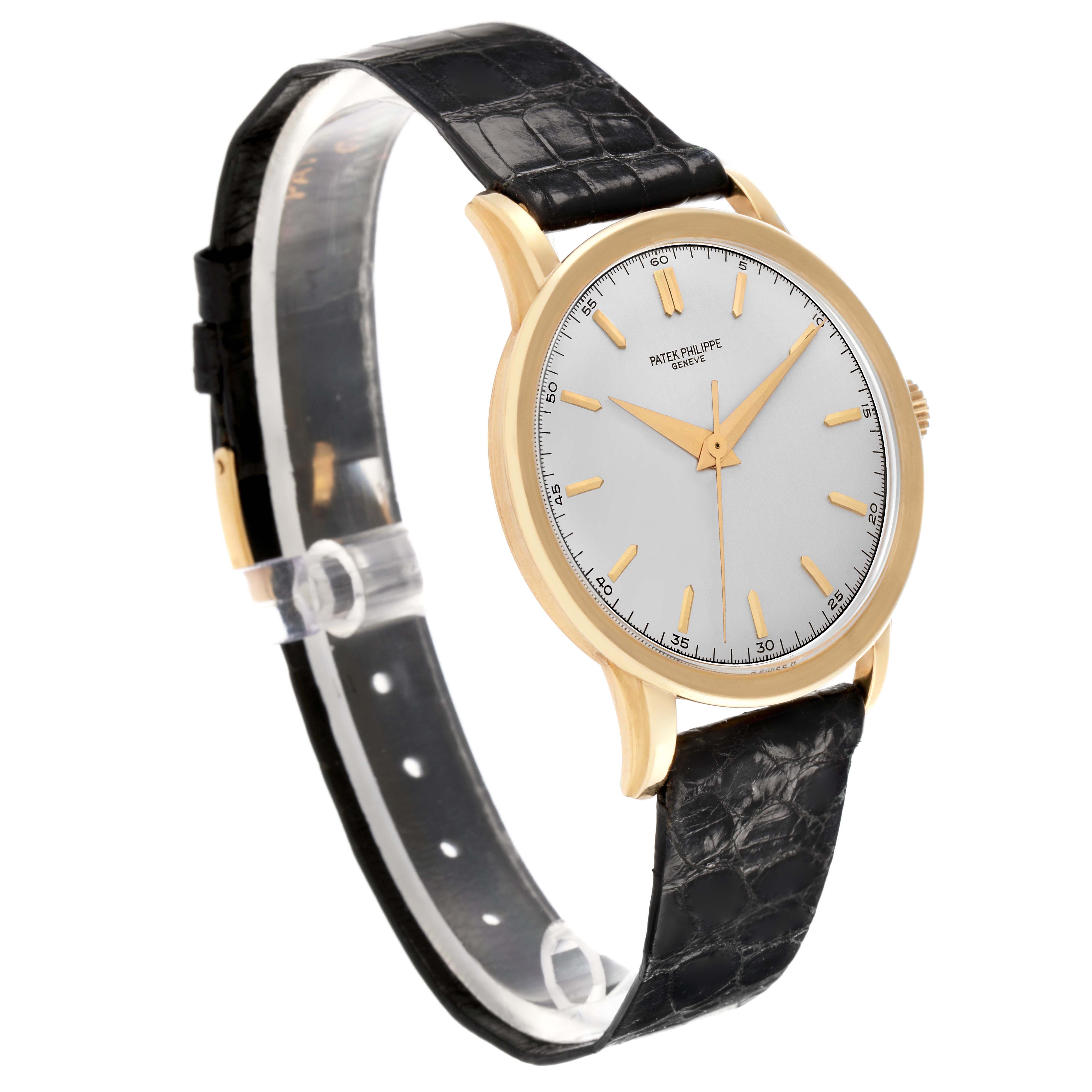 The Patek Philippe Calatrava 2481 Men's Yellow Gold Silver Dial watch is shown at a slight angle, highlighting its face, gold case, and black leather strap.