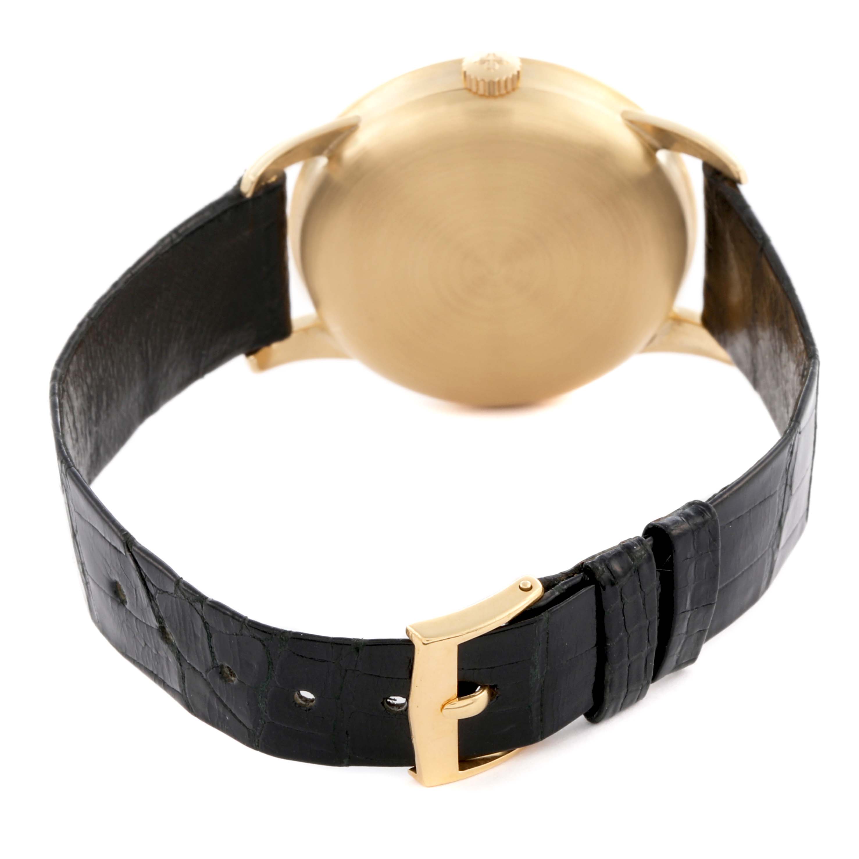 The image shows the back view of a Patek Philippe Calatrava 2481 Men's Yellow Gold Silver Dial 2481 Men's Yellow Gold Silver Dial watch featuring the case, lugs, crown, and leather strap with buckle.