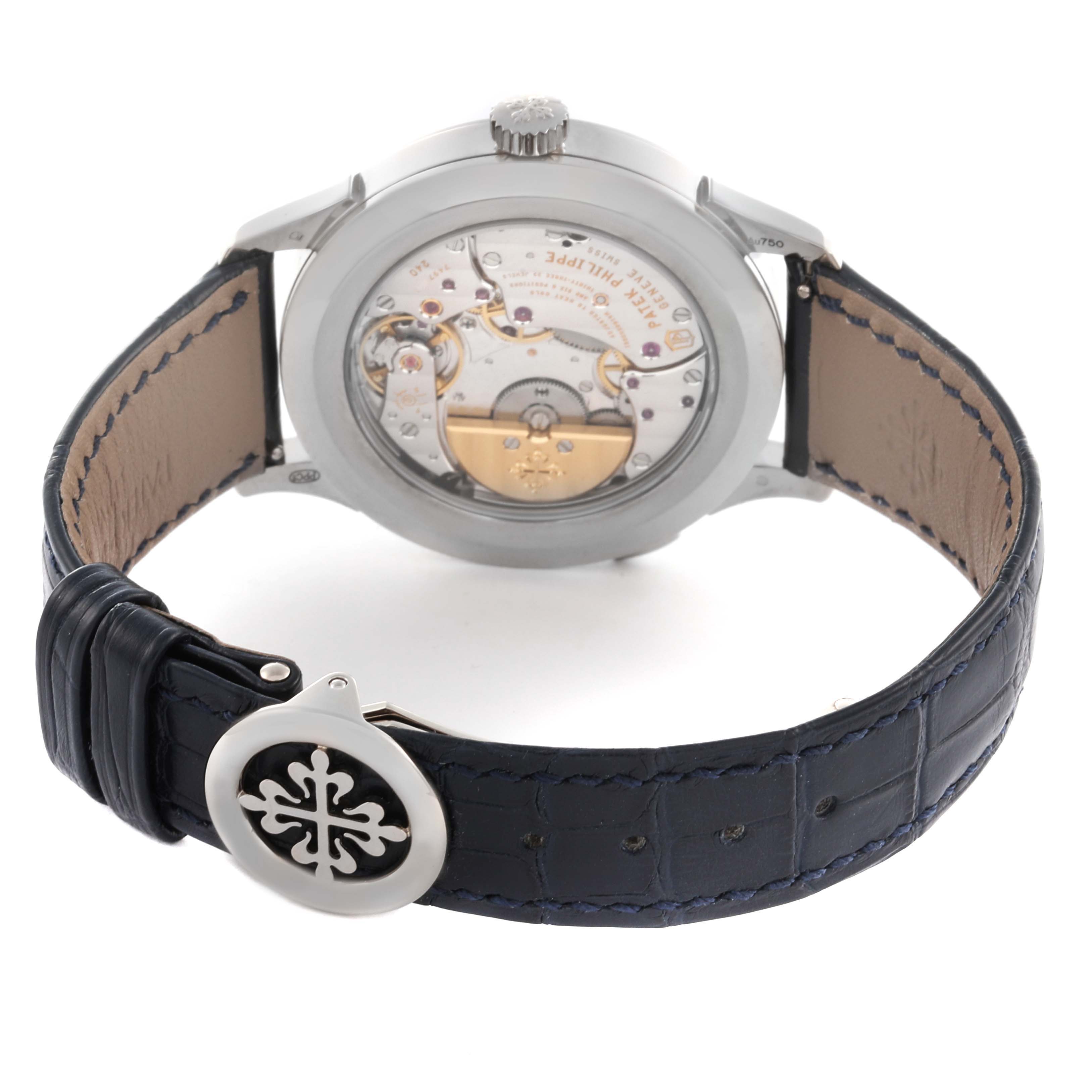 The image shows the back view of a Patek Philippe Complications 5231G-001 Men's White Gold Silver Dial watch, highlighting the movement and leather strap with logo clasp.