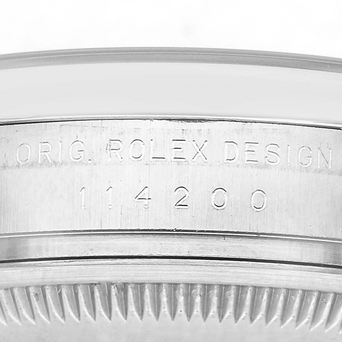 The image shows the side engraving on the case of a Rolex Air-King 114200 Men's Stainless Steel White Dial watch, displaying the model and design details.