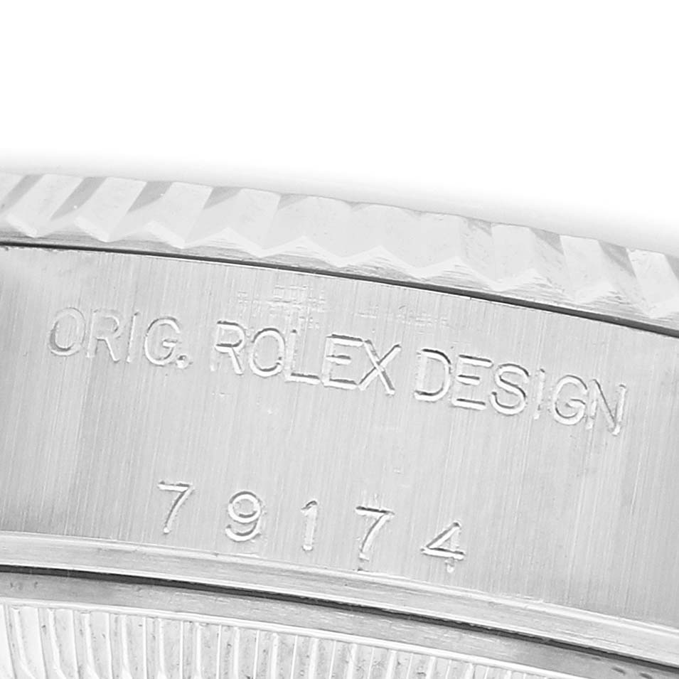 The image shows a close-up of the side of a Rolex Datejust 79174 Women's Steel and Gold (two tone) Silver Dial watch, highlighting the bezel and engraved design markings.