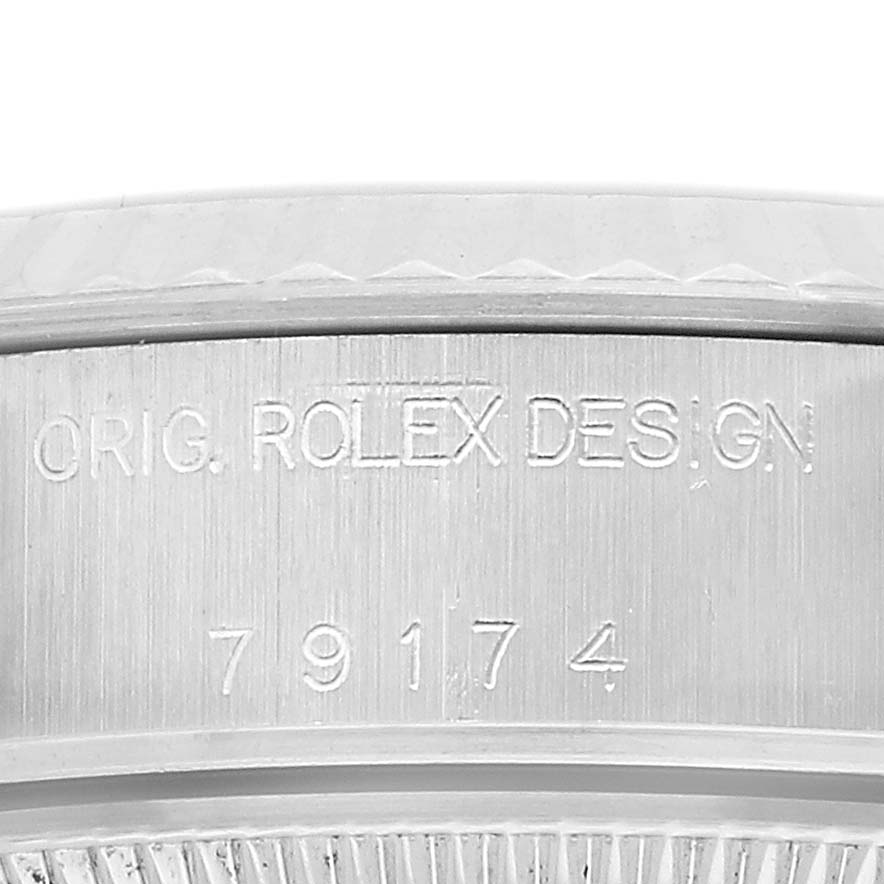 The image shows the side of a Rolex Datejust 79174 Women's Stainless Steel Silver Dial watch case with engraving, viewed close-up.