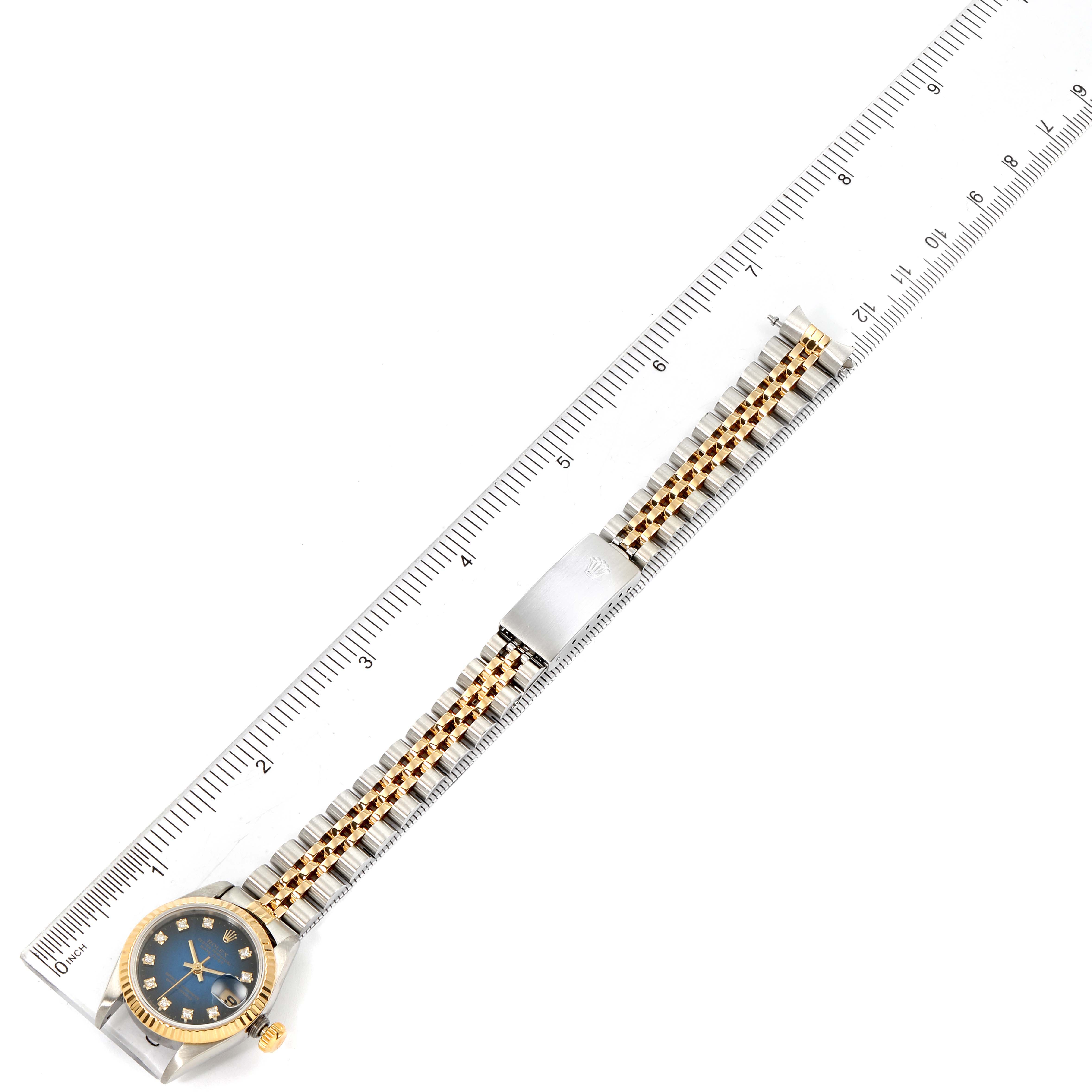 The image shows a Rolex Datejust 69173 Women's Steel and Gold (two tone) Blue Dial 69173 Women's Steel and Gold (two tone) Blue Dial watch laid flat next to a ruler, showing its bracelet and face from an aerial view.