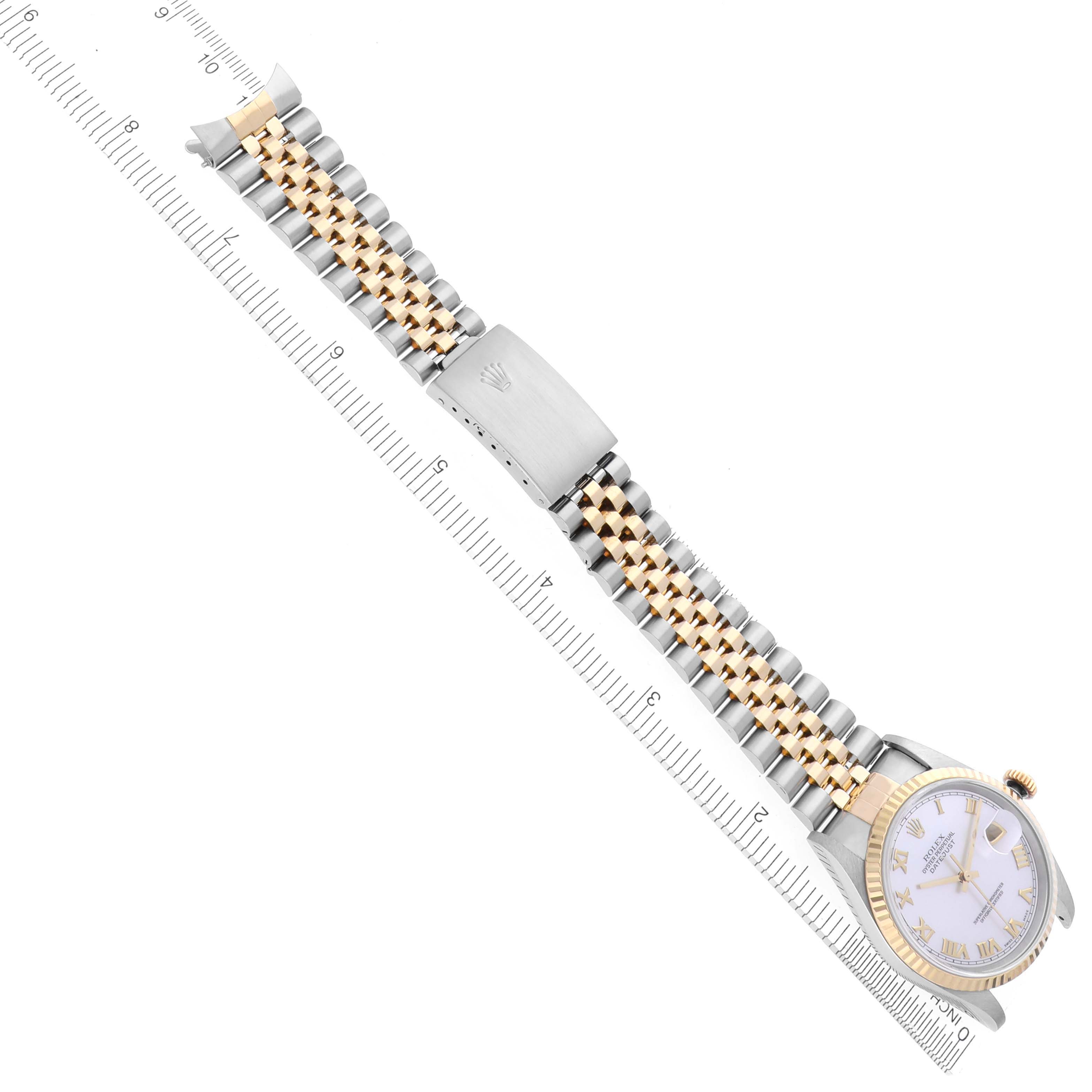 The Rolex Datejust 16233 Men's Steel and Gold (two tone) Mother of Pearl Dial 16233 Men's Steel and Gold (two tone) Mother of Pearl Dial watch is shown laid flat, highlighting the two-tone bracelet, clasp, and face, alongside a ruler for size.