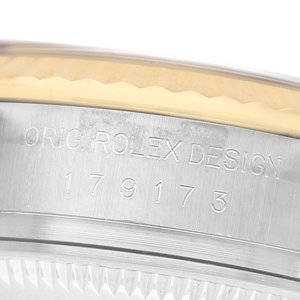 The image shows the side of a Rolex Datejust 179173 Women's Steel and Gold (two tone) Blue Dial, highlighting the engraved model number and part of the bezel's edge.