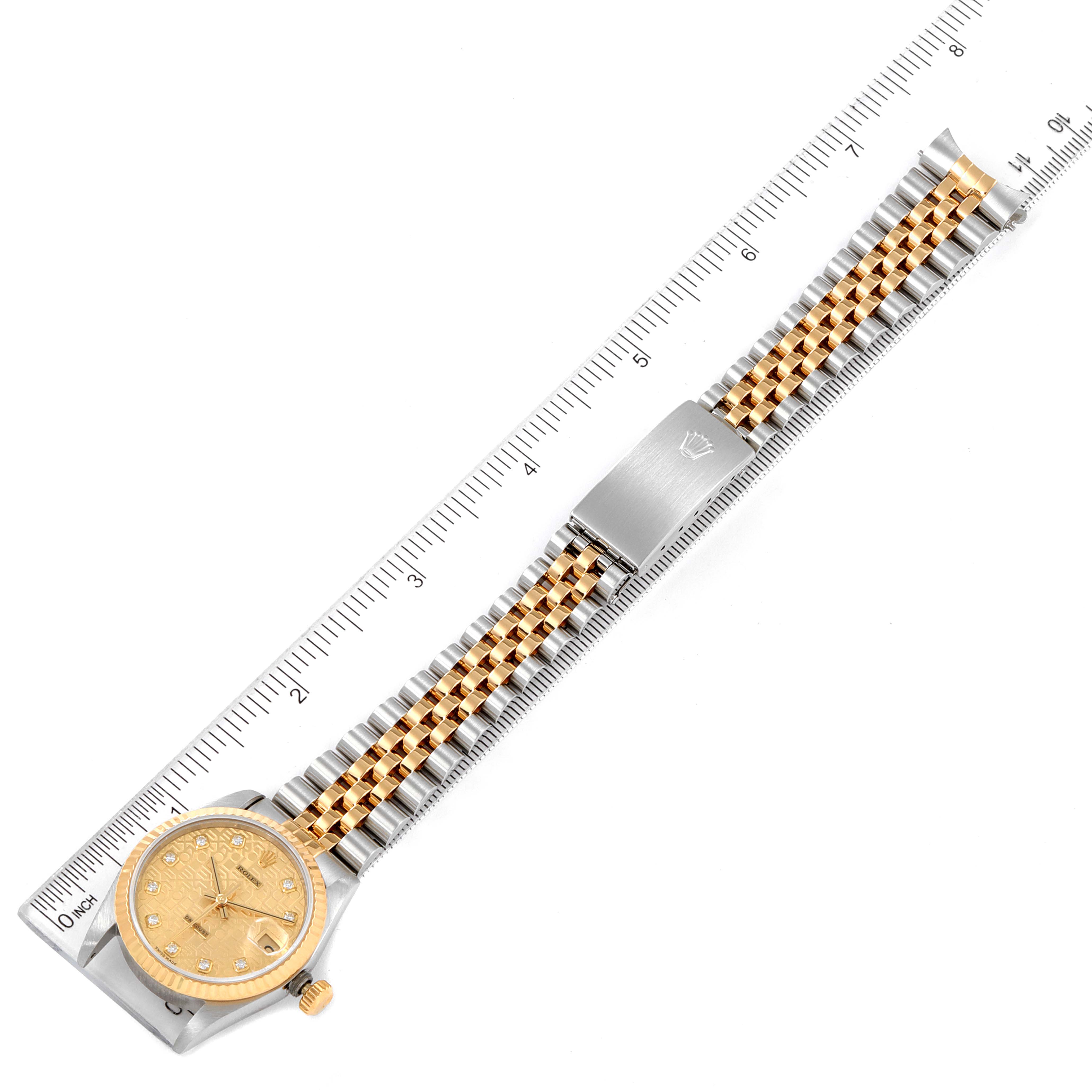 The image shows a top-down view of a Rolex Mid-Size 68273 Women's Steel and Gold (two tone) Champagne Dial 68273 Women's Steel and Gold (two tone) Champagne Dial model watch, highlighting the bracelet and clasp next to a ruler for scale.