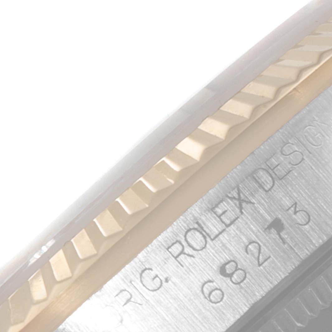 This close-up image shows the bezel and a part of the case with engraved text of a Mid-Size Rolex watch model.