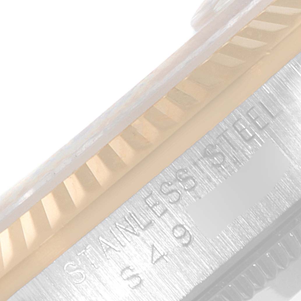This image shows a close-up of the stainless steel bezel and engraved serial number of a mid-size Rolex watch.