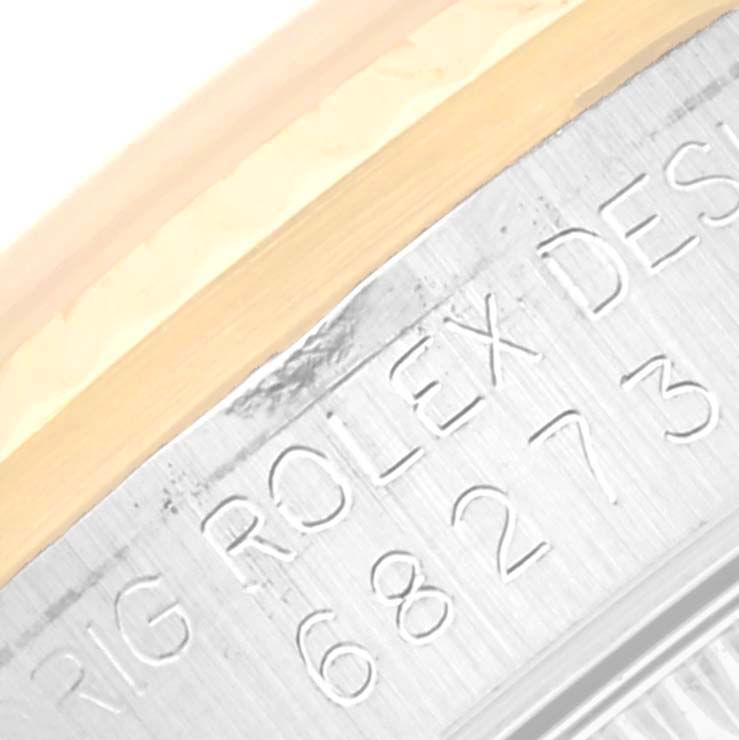 This close-up image shows the engraved bezel of a Mid-Size Rolex watch, displaying the model number and brand name.