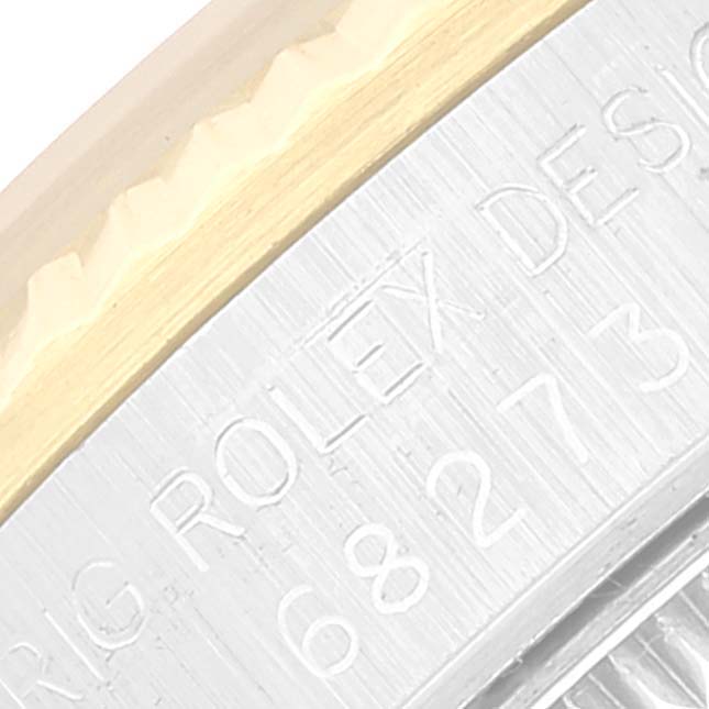 This close-up shot of the Rolex Mid-Size 68273 Women
s Steel and Gold (two tone) Black Dial 68273 Women
s Steel and Gold (two tone) Black Dial model features the watch
s engraved side with part of the bezel.