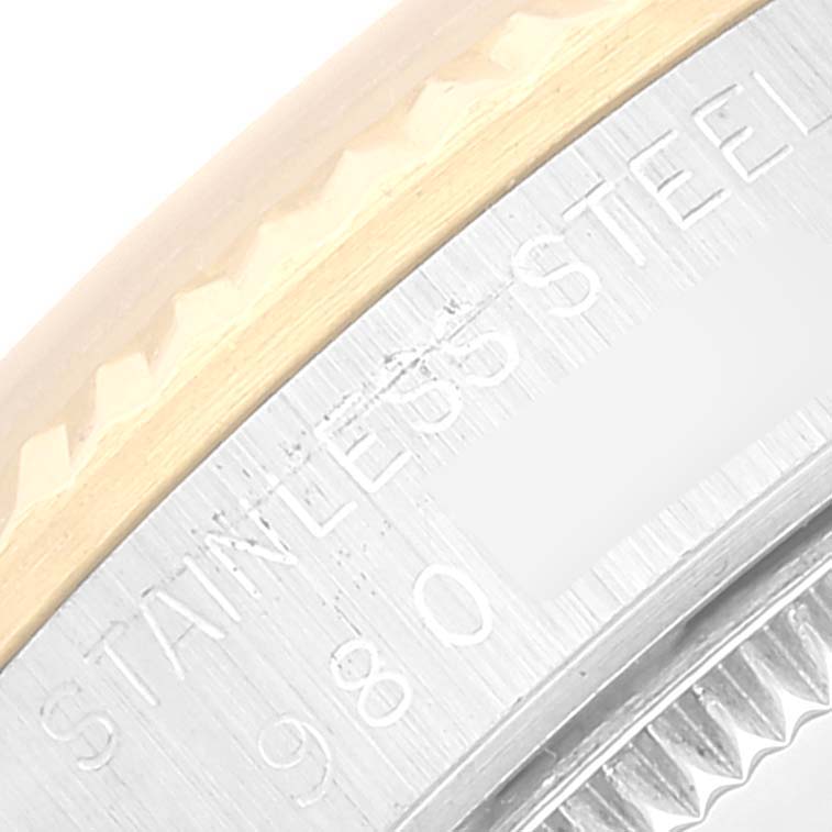 The image shows a close-up of the side engraving on the bezel and case of a Mid-Size Rolex watch, indicating "STAINLESS STEEL."