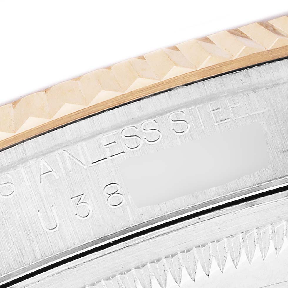 The image shows a close-up of the fluted bezel and engraved inner side of a Rolex Datejust 16233 Men's Steel and Gold (two tone) White Dial watch.