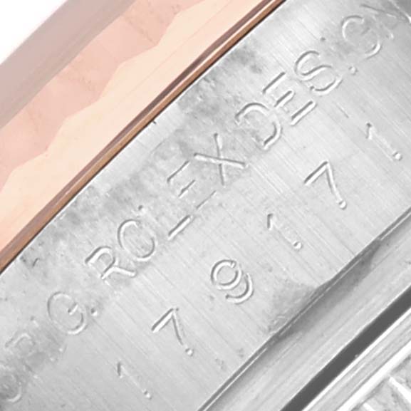 The image shows a close-up of the Rolex Datejust 179171 Women's Steel and Gold (two tone) Pink Dial 179171 Women's Steel and Gold (two tone) Pink Dial's side, highlighting its bezel and engraved details.