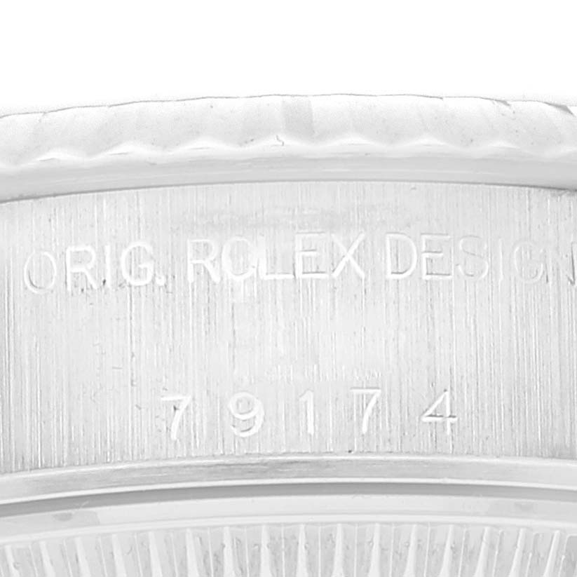 The image shows a close-up of the engravings on the side of a Rolex Datejust 79174 Women's Stainless Steel Pink Dial 79174 Women's Stainless Steel Pink Dial watch case, including the "ORIG. ROLEX DESIGN" inscription and model number.