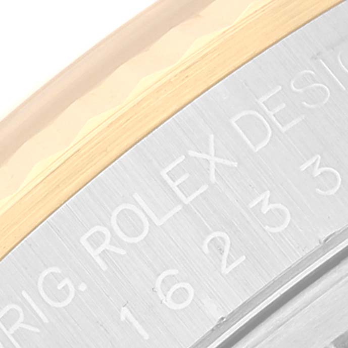 The image shows a close-up of the Rolex Datejust 16233 Men's Steel and Gold (two tone) Mother of Pearl Dial 16233 Men's Steel and Gold (two tone) Mother of Pearl Dial model's bezel and inner edge, featuring engraved text.