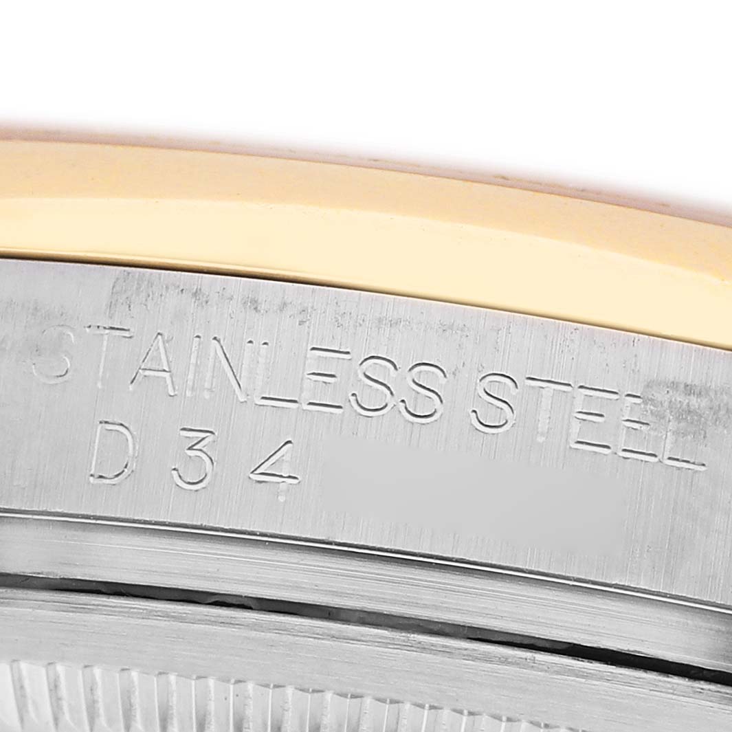 The image shows a close-up of the case edge of a Rolex Datejust 116203 Men's Steel and Gold (two tone) Mother of Pearl Dial, highlighting the stainless steel part with engraved text.