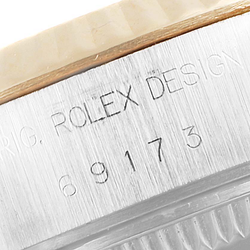 This image shows an extreme close-up of the side casing of a Rolex Datejust 69173 Women's Steel and Gold (two tone) Silver Dial 69173 Women's Steel and Gold (two tone) Silver Dial watch, highlighting its engraved serial number.