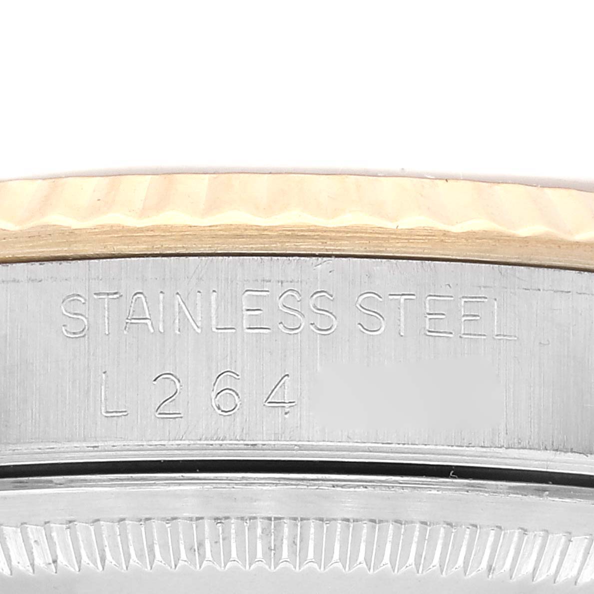 This close-up image shows the side detail of a Rolex Datejust 16233 Men's Steel and Gold (two tone) White Dial 16233 Men's Steel and Gold (two tone) White Dial watch, highlighting the engraved text and the fluted bezel.