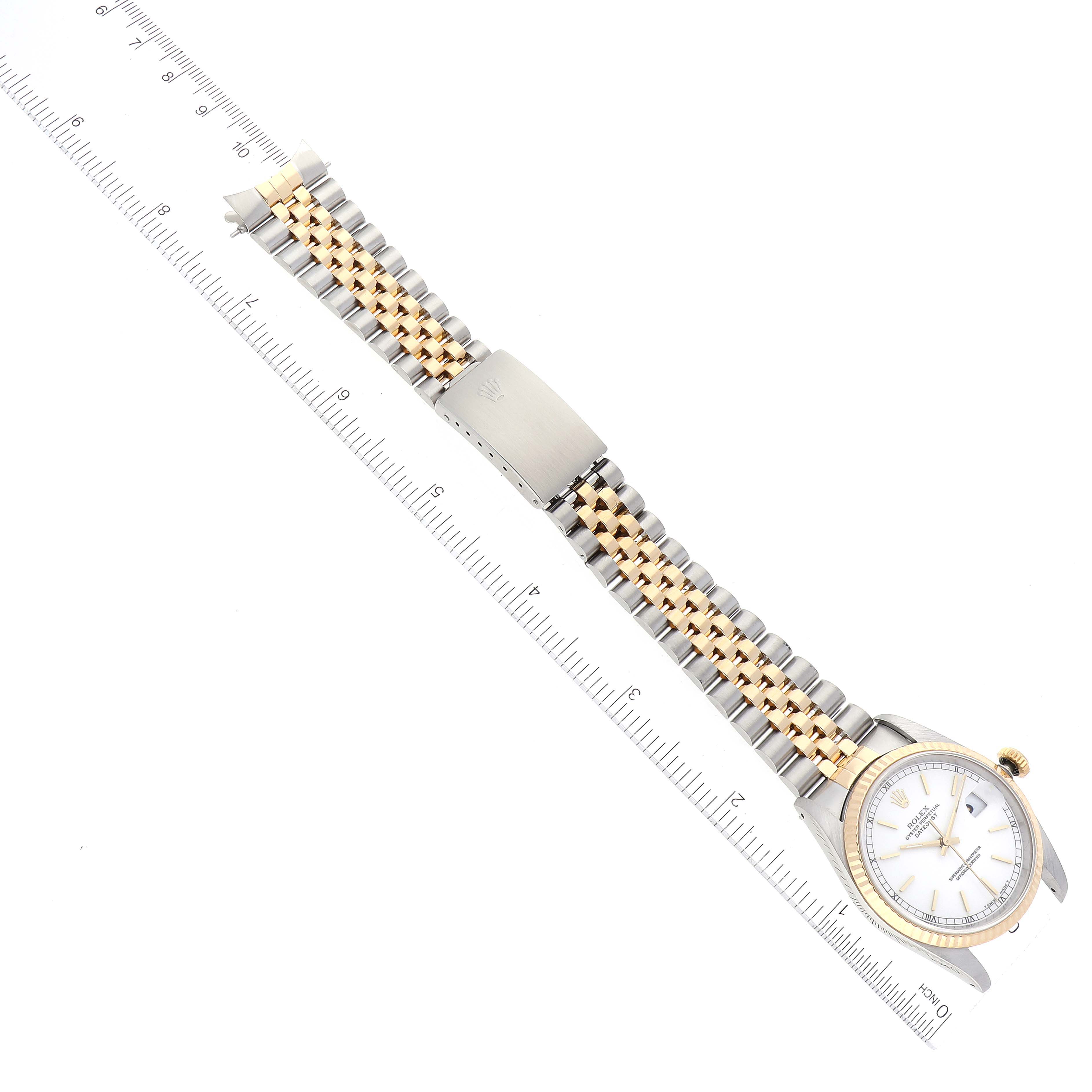 The image displays a Rolex Datejust 16233 Men's Steel and Gold (two tone) White Dial 16233 Men's Steel and Gold (two tone) White Dial watch laid flat next to a ruler, showing the face, bezel, bracelet, and clasp.