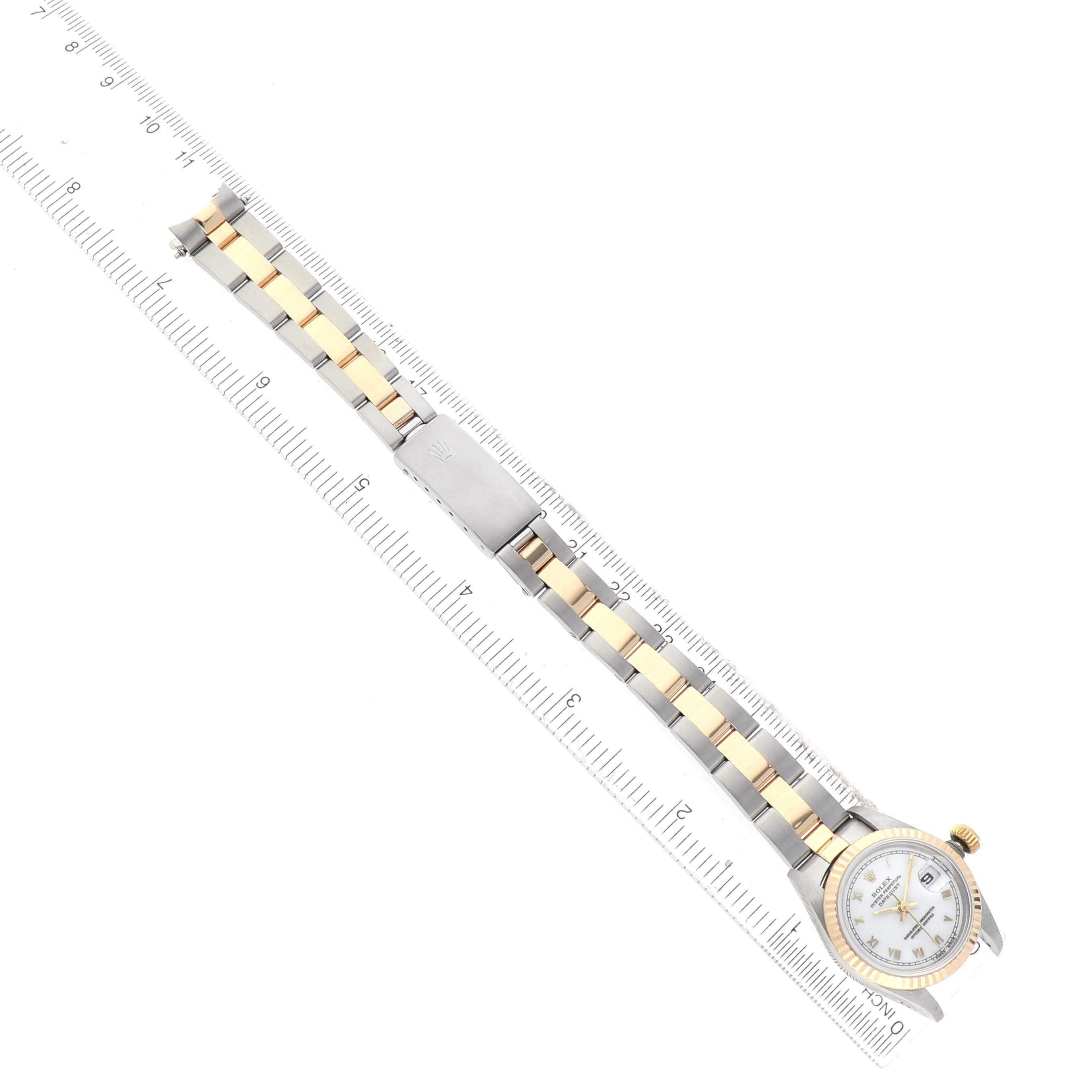 The Rolex Datejust 69173 Women's Steel and Gold (two tone) White Dial watch is shown from a top-down angle, displaying the bracelet and watch face alongside a ruler for scale.