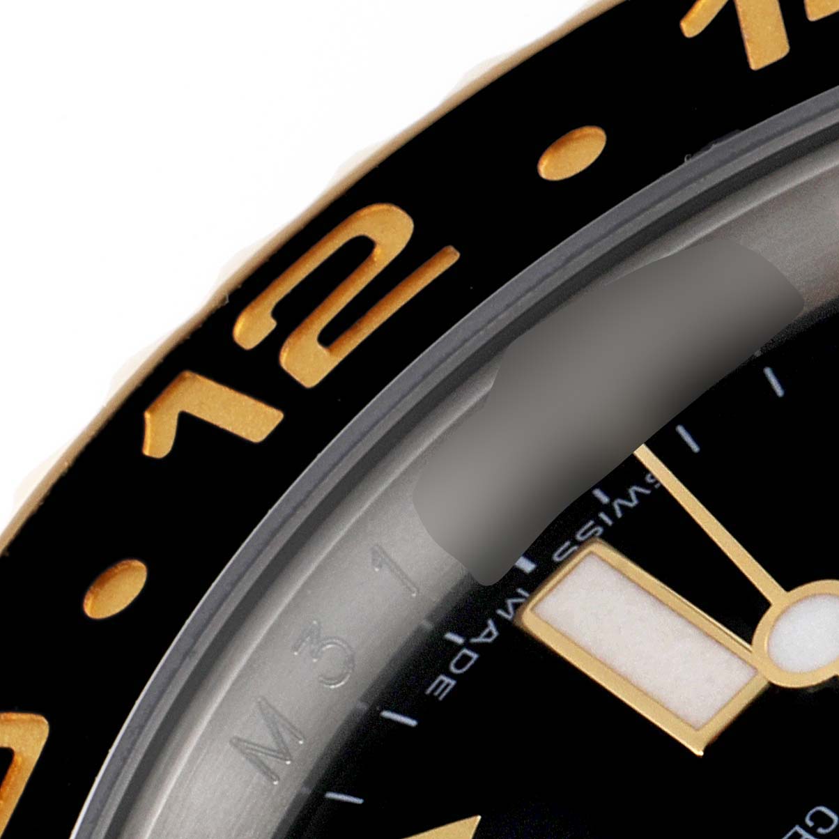 The image shows a close-up of the bezel and part of the dial of the Rolex GMT-Master 116713 Men's Steel and Gold (two tone) Black Dial 116713 Men's Steel and Gold (two tone) Black Dial watch.