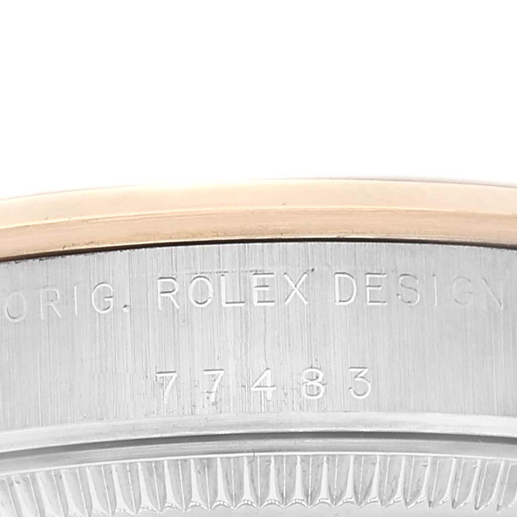 The image shows the edge of the case back and part of the bezel of a Mid-Size Rolex watch with the model number 77483 engraved.