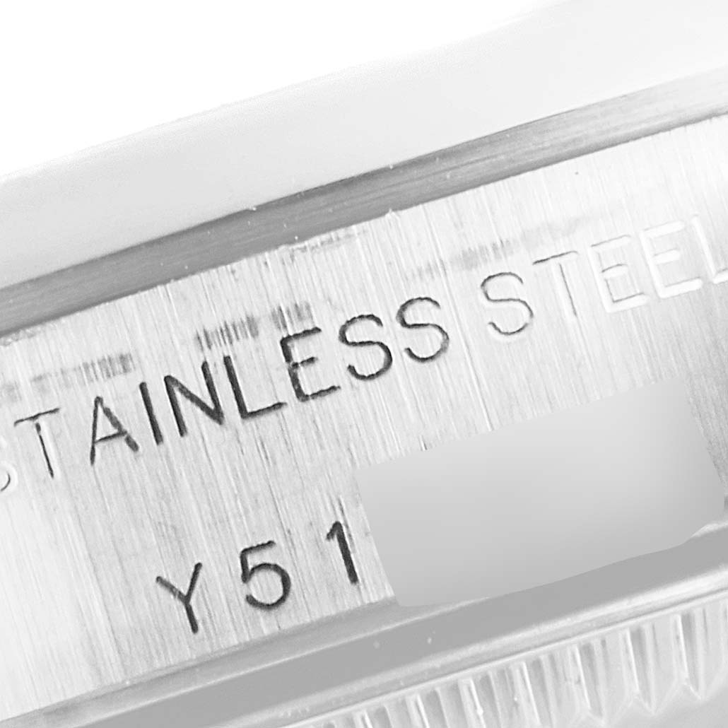 The image shows a close-up of the side of a Rolex Oyster Perpetual 76080 Women's Stainless Steel Pink Dial 76080 Women's Stainless Steel Pink Dial watch, focusing on the engraved text "STAINLESS STEEL" and part of the serial number.