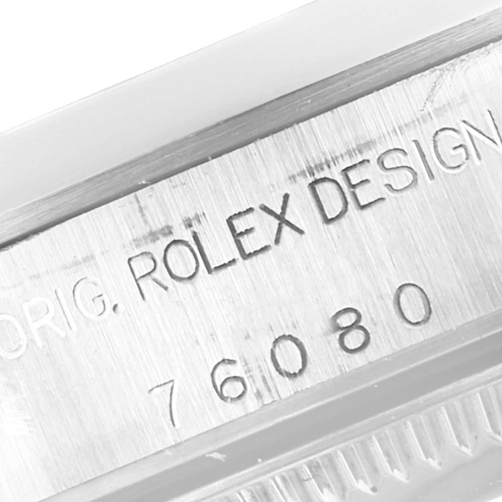 This image shows a close-up of the engraved case side of a Rolex Oyster Perpetual 76080 Women's Stainless Steel Pink Dial 76080 Women's Stainless Steel Pink Dial watch, highlighting the model number and "Rolex Design" inscription.