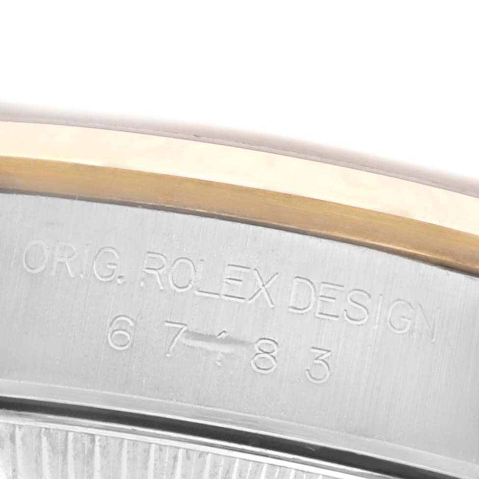The image shows a close-up of the Rolex Oyster Perpetual 67183 Women's Steel and Gold (two tone) Grey Dial 67183 Women's Steel and Gold (two tone) Grey Dial case edge with engraving details.