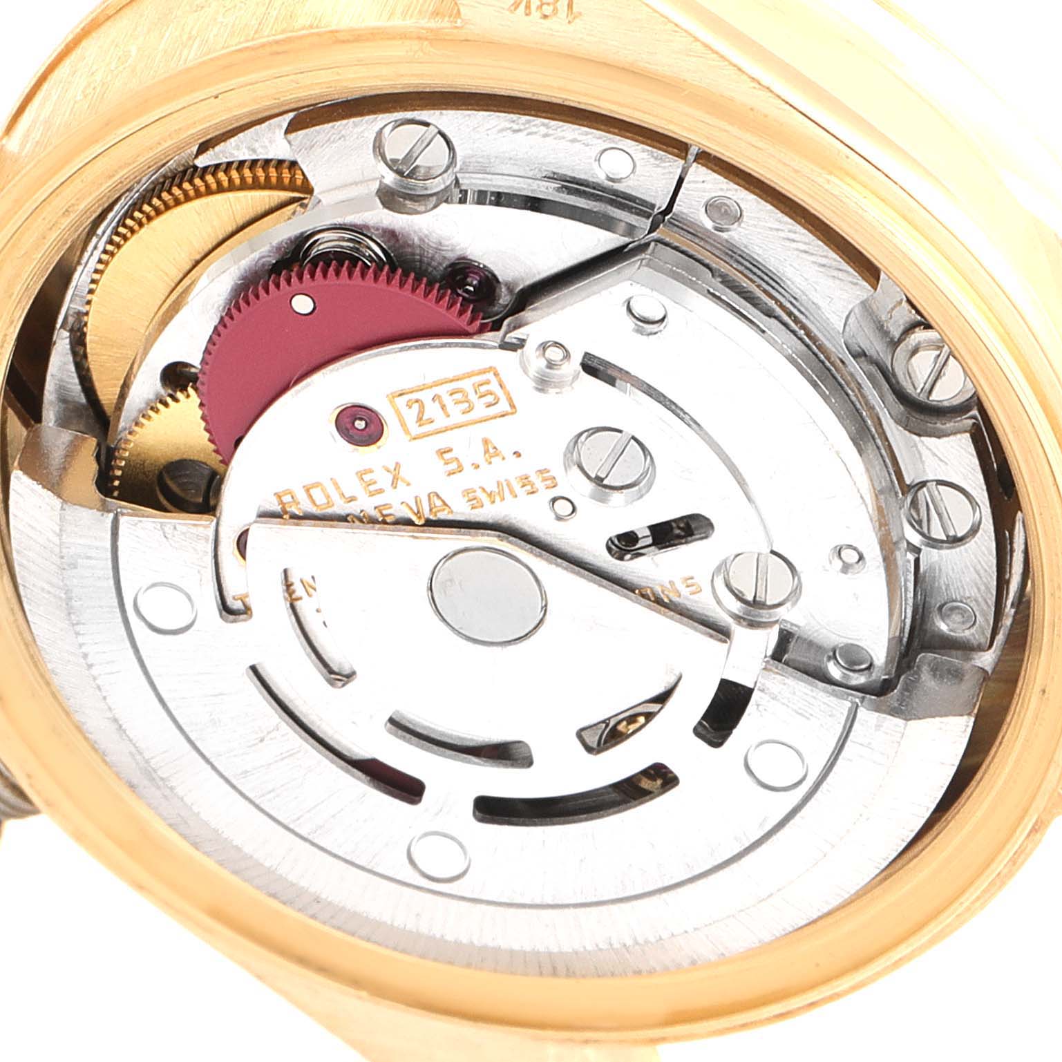 The image shows the inner mechanism of the Rolex President 69178 Women
s Yellow Gold White Dial 69178 Women
s Yellow Gold White Dial model watch from a close-up, back angle, highlighting gears and movement components.