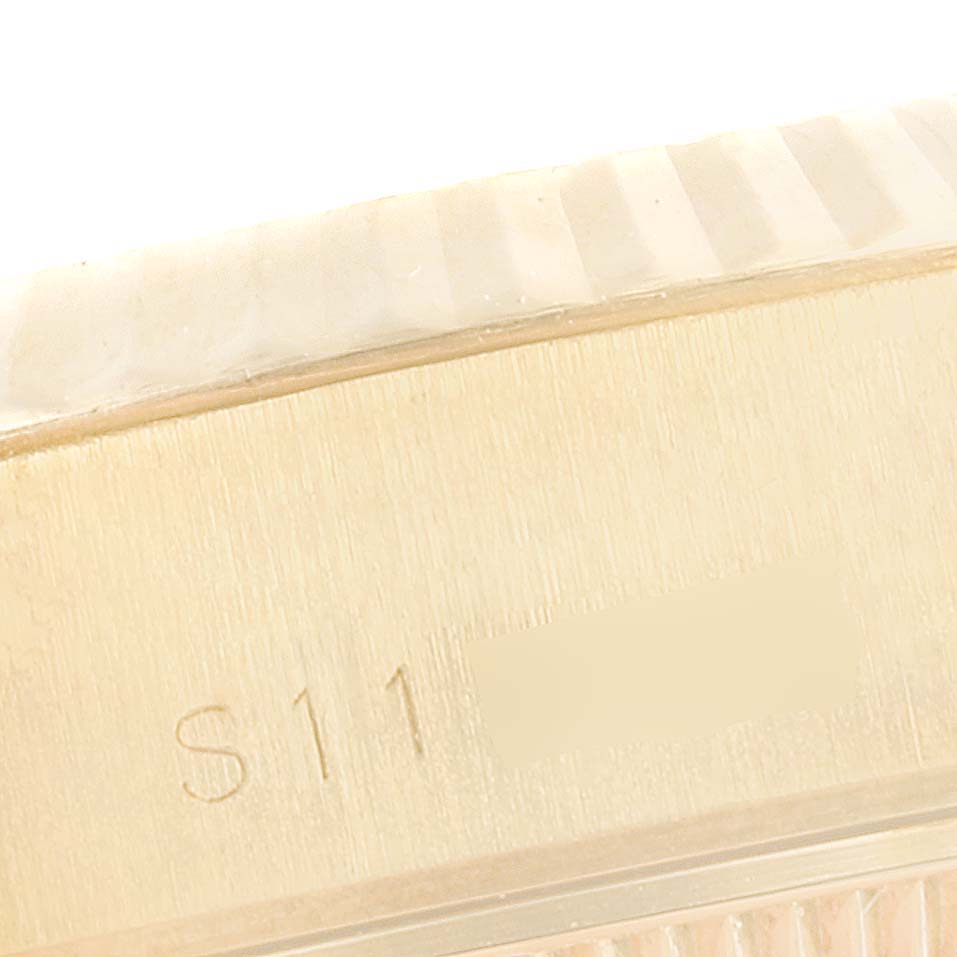 This is a close-up of the side of a Rolex President 69178 Women
s Yellow Gold Champagne Dial 69178 Women
s Yellow Gold Champagne Dial model watch, showing the edge of the bezel and part of the engraved serial number.