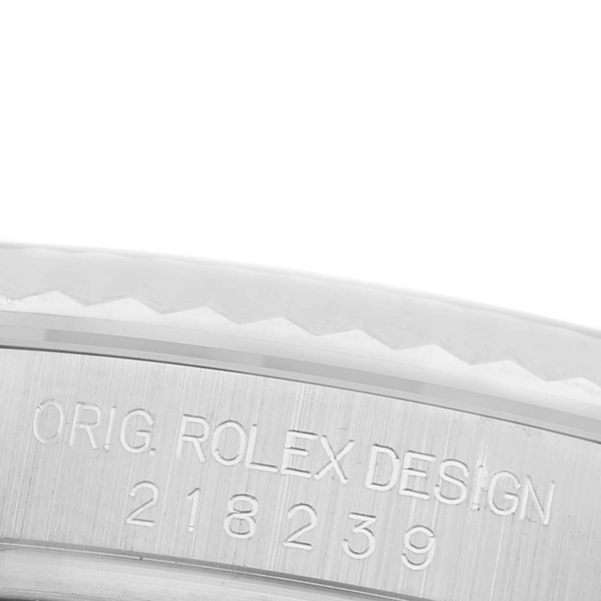 The image shows the side engraving of the bezel on a Rolex President 218239 Men's White Gold Black Dial 218239 Men's White Gold Black Dial model, displaying "ORIG ROLEX DESIGN 218239."