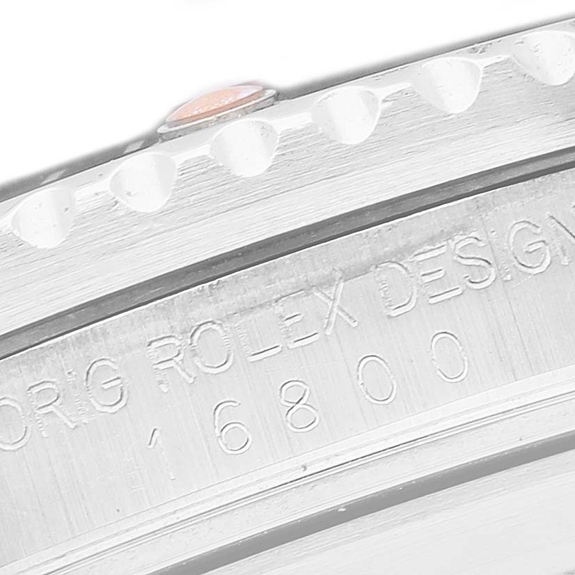 The image shows a close-up of the engraved side of the case and bezel edge of a Rolex Submariner 168000 Men's Stainless Steel Black Dial watch.