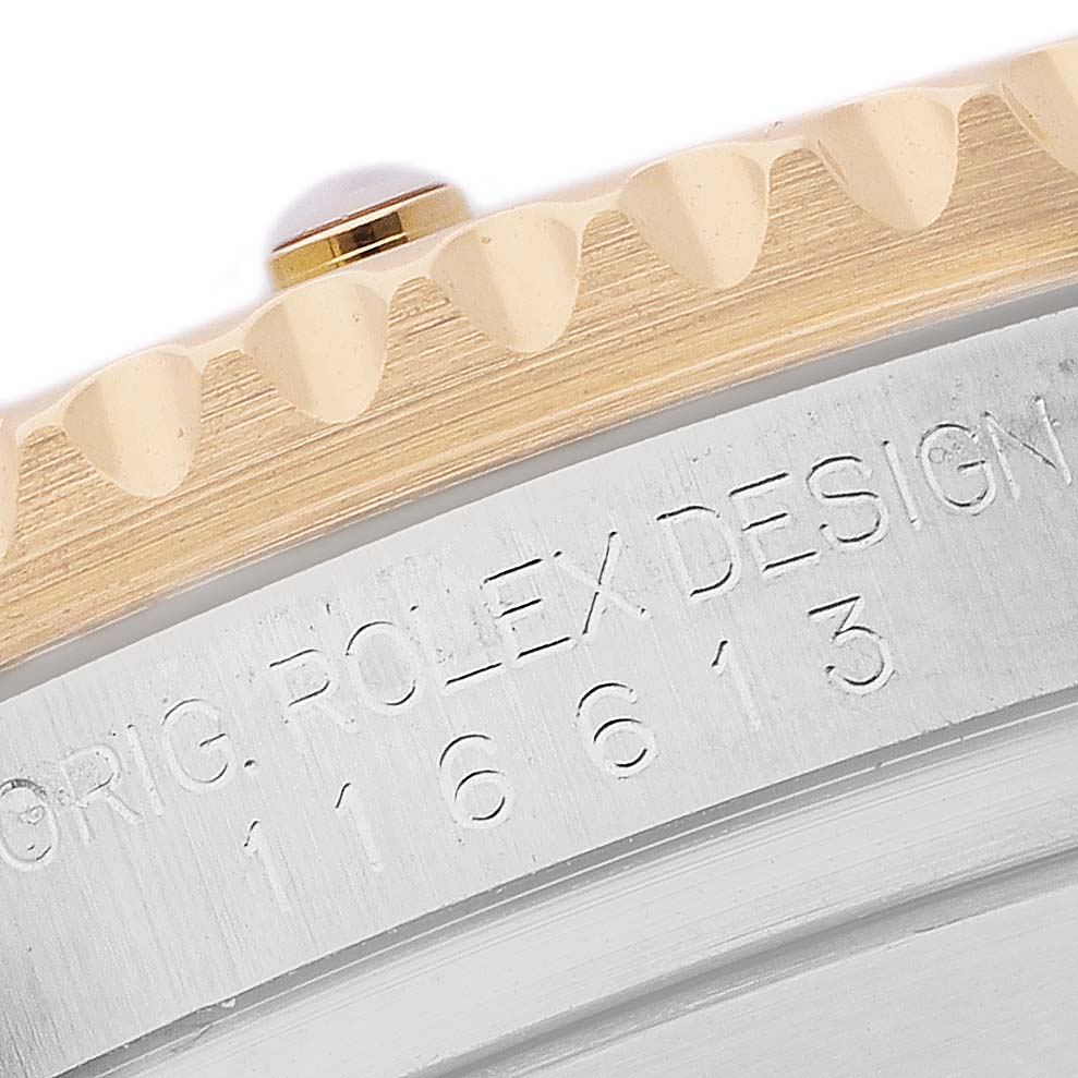 The image shows a close-up of the Rolex Submariner 116613 Men's Steel and Gold (two tone) Blue Dial's bezel and engraved side, highlighting the model number.