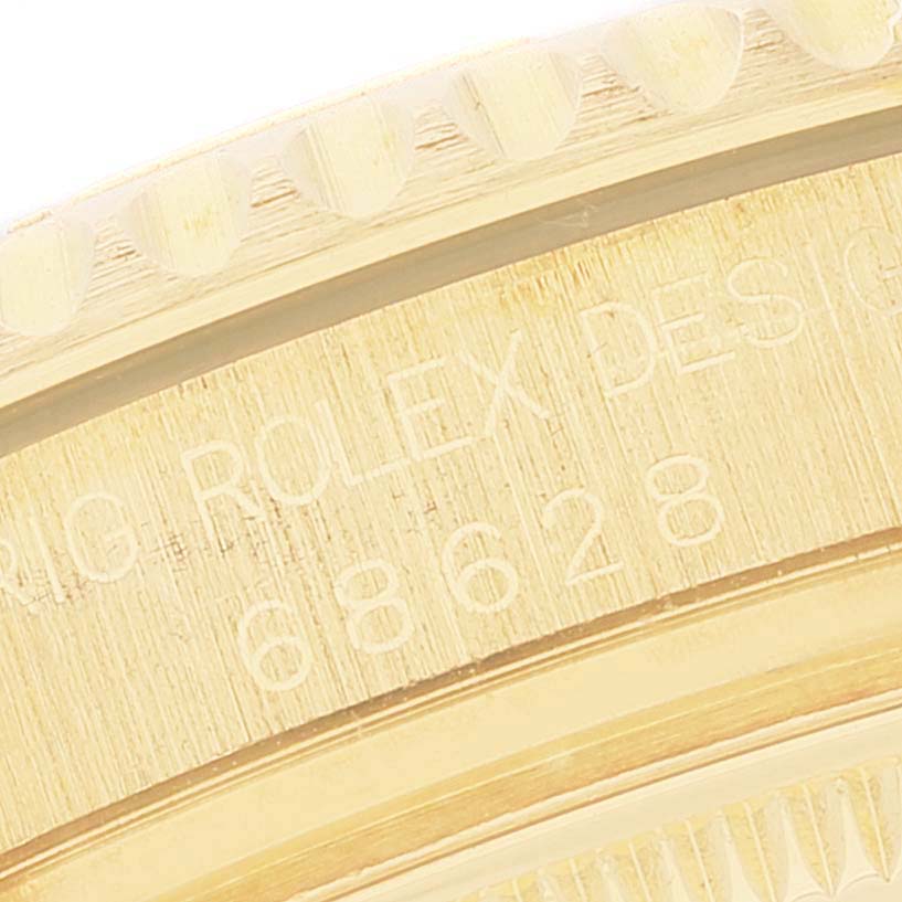The image shows a close-up of the engraved bezel and case side of a Rolex Yacht-Master 68628 Men's Yellow Gold Blue Dial 68628 Men's Yellow Gold Blue Dial model watch.