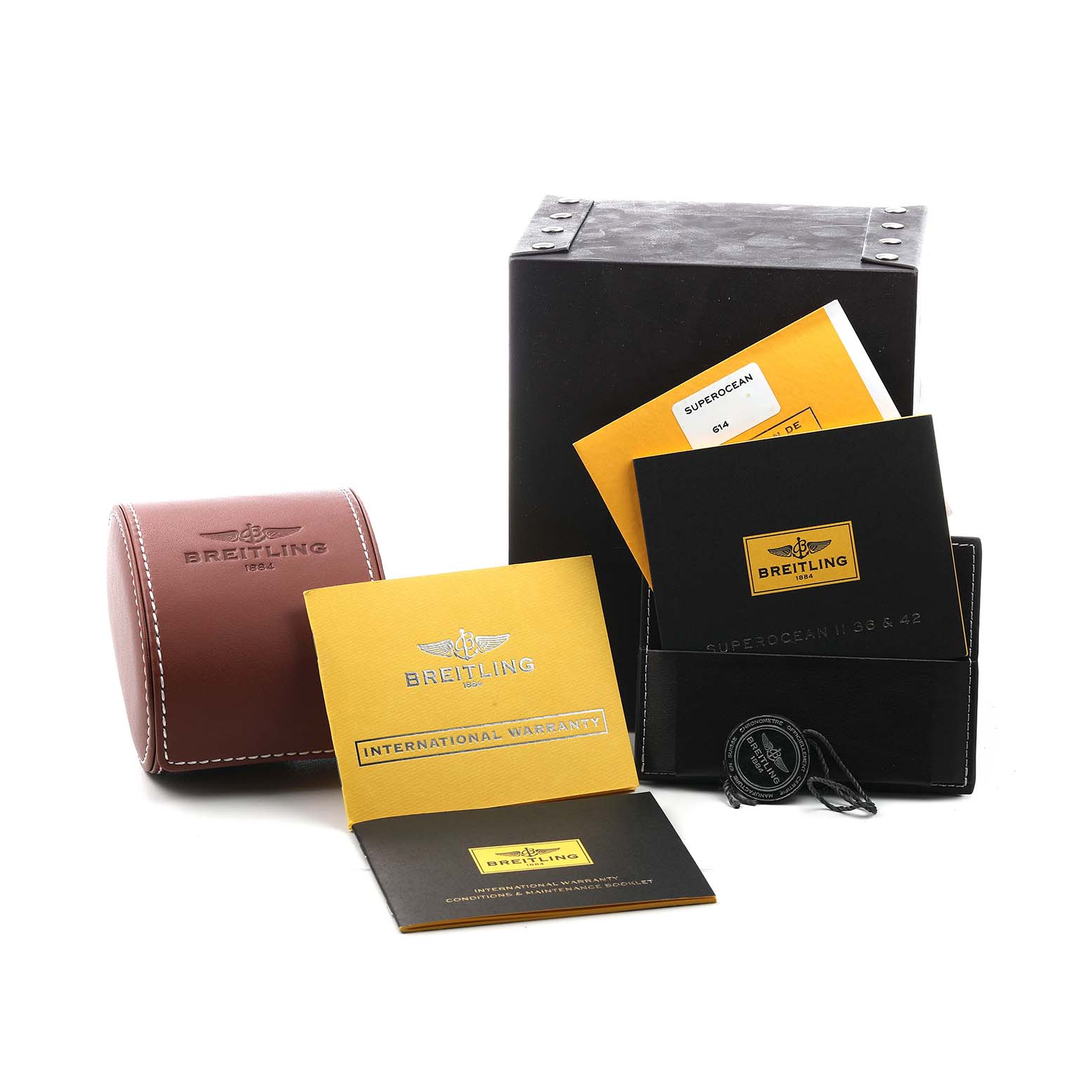 The image shows Breitling Superocean A17365 Men's Stainless Steel Black Dial watch accessories, including a box, warranty card, booklet, and a brown case.