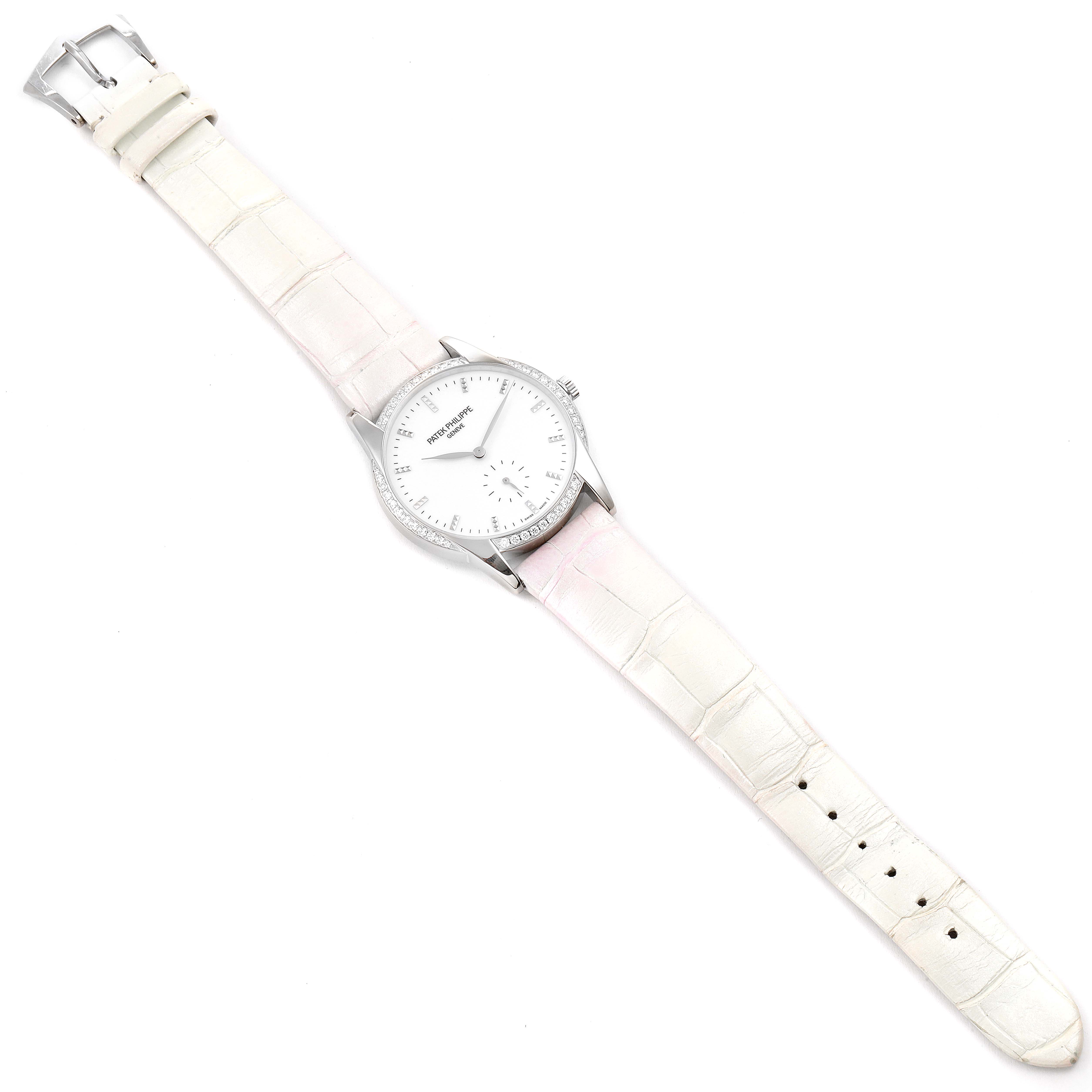 This image shows a top-down view of a Patek Philippe Calatrava 7122/200G Women's White Gold White Dial 7122/200G Women's White Gold White Dial watch with a white dial and light-colored strap.