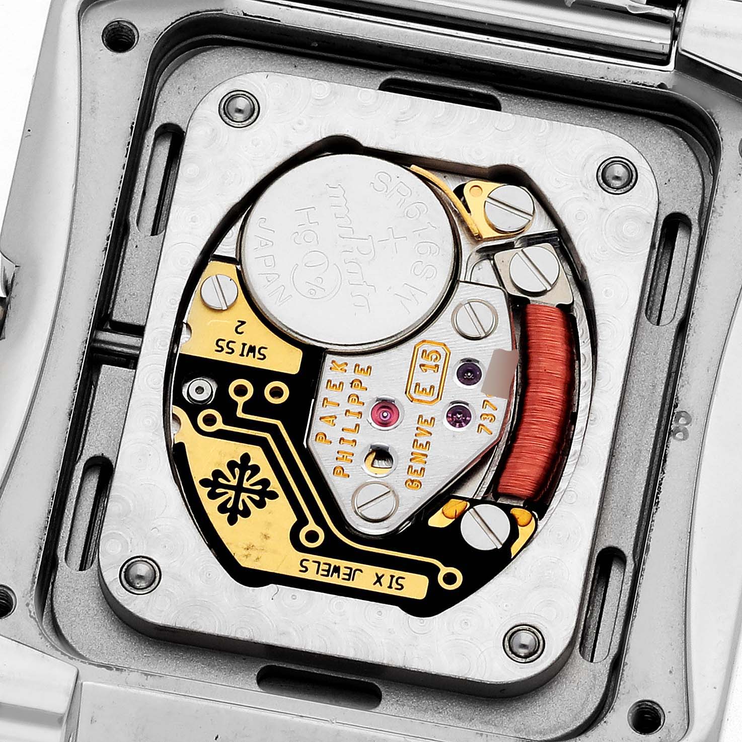 The image shows the back of a Patek Philippe Twenty-4 4910/1200A-001 Women's Stainless Steel Blue Dial 4910/1200A-001 Women's Stainless Steel Blue Dial's movement with circuit details and a battery visible.