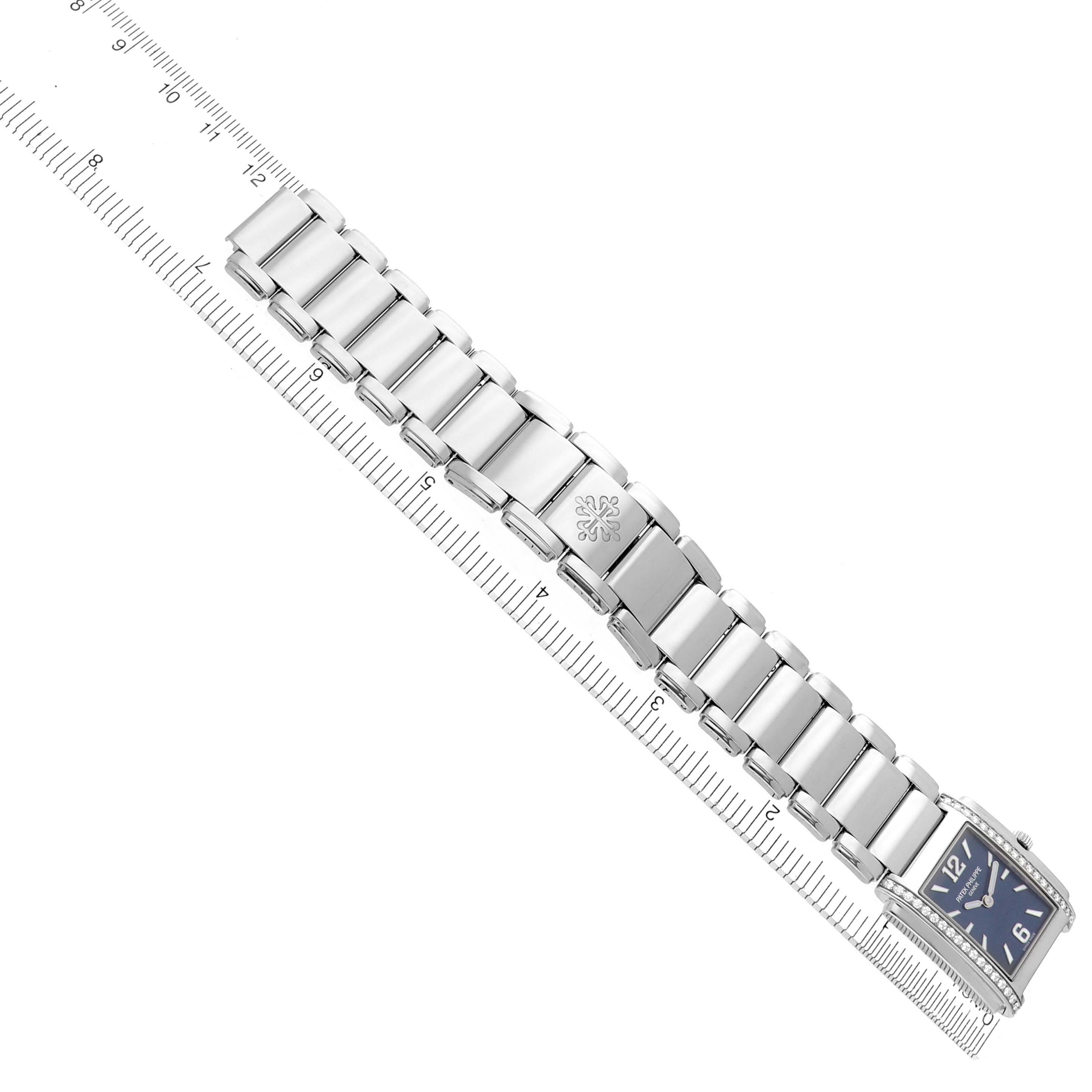The image shows the Patek Philippe Twenty-4 4910/1200A-001 Women's Stainless Steel Blue Dial 4910/1200A-001 Women's Stainless Steel Blue Dial watch from a top view, highlighting its bracelet and rectangular face with a ruler for scale.